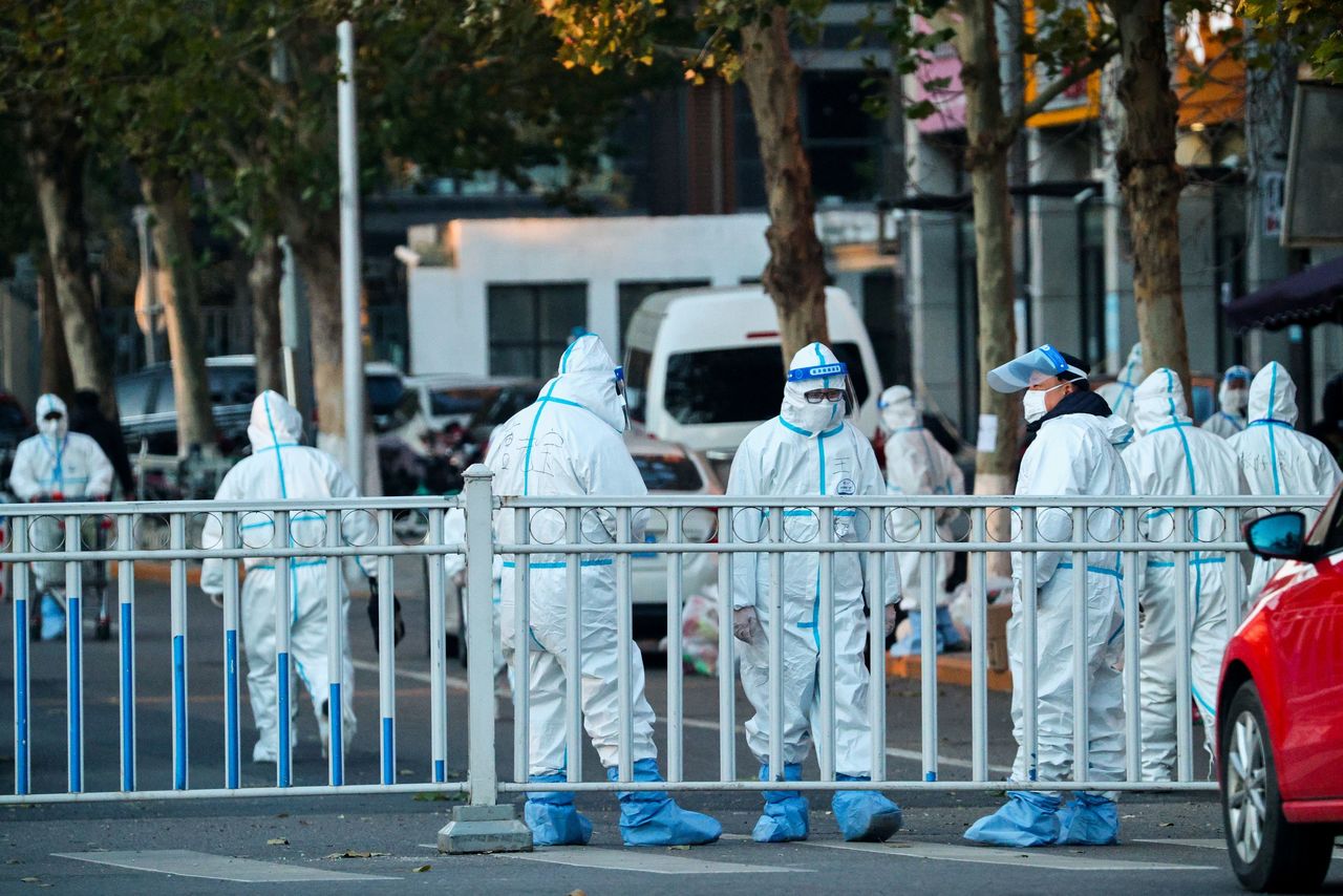 Security personnel in protective suits guard the perimeters of a residential compound that was locked down after a local outbreak of the coronavirus disease (COVID-19) in Beijing, China, November 11, 2021. REUTERS/Thomas Peter