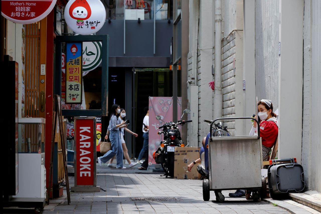 FILE PHOTO: An employee takes a break outside a shop amid the coronavirus disease (COVID-19) pandemic in Seoul, South Korea, July 9, 2021. REUTERS/ Heo Ran