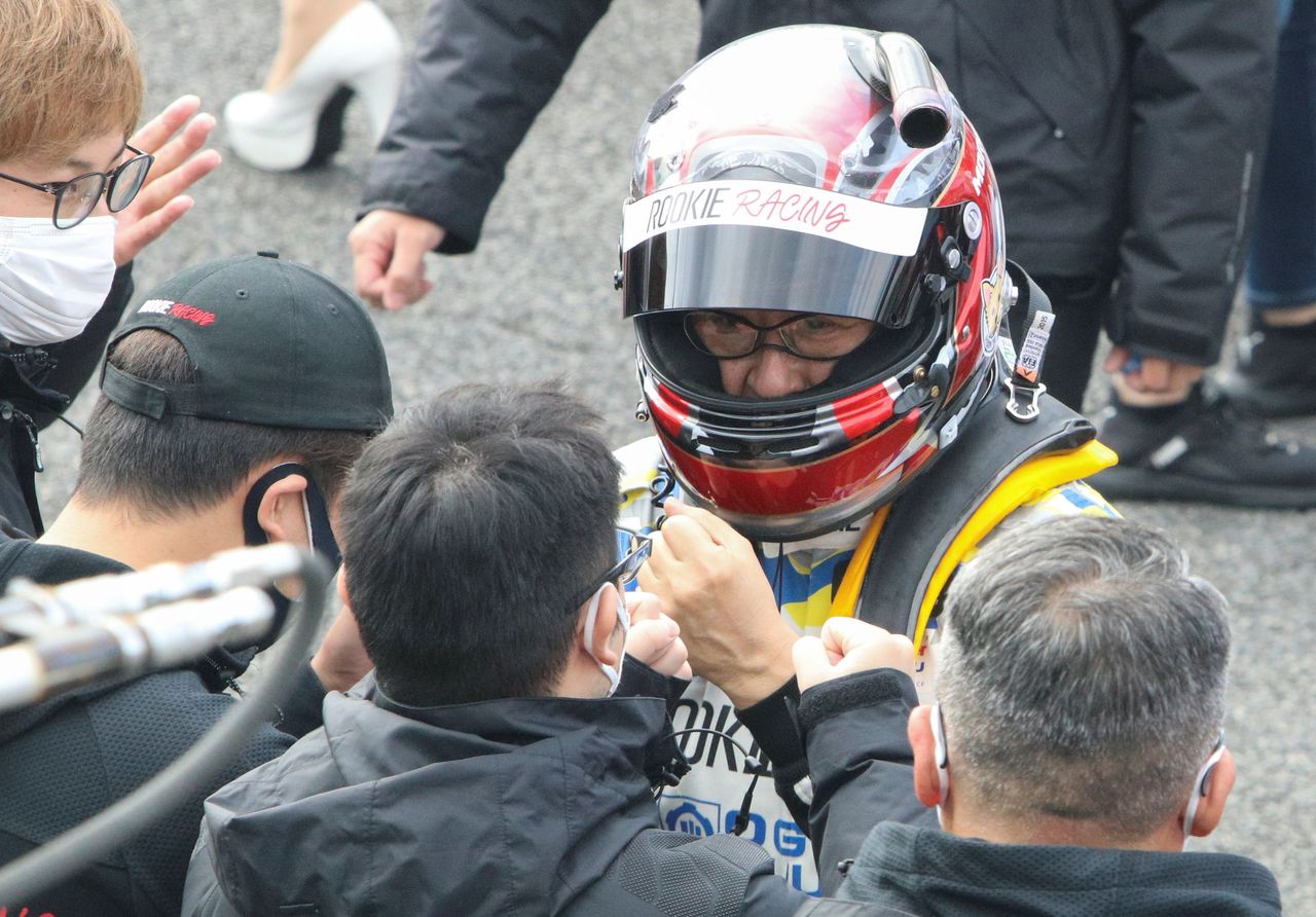Toyota Motor Corporation President Akio Toyoda wearing a racing suit and helmet bums fists with his son Daisuke after driving Toyota’s hydrogen engine car at Okayama International Circuit in Mimasaka, Okayama Prefecture, Japan November 13, 2021. REUTERS/Tim Kelly