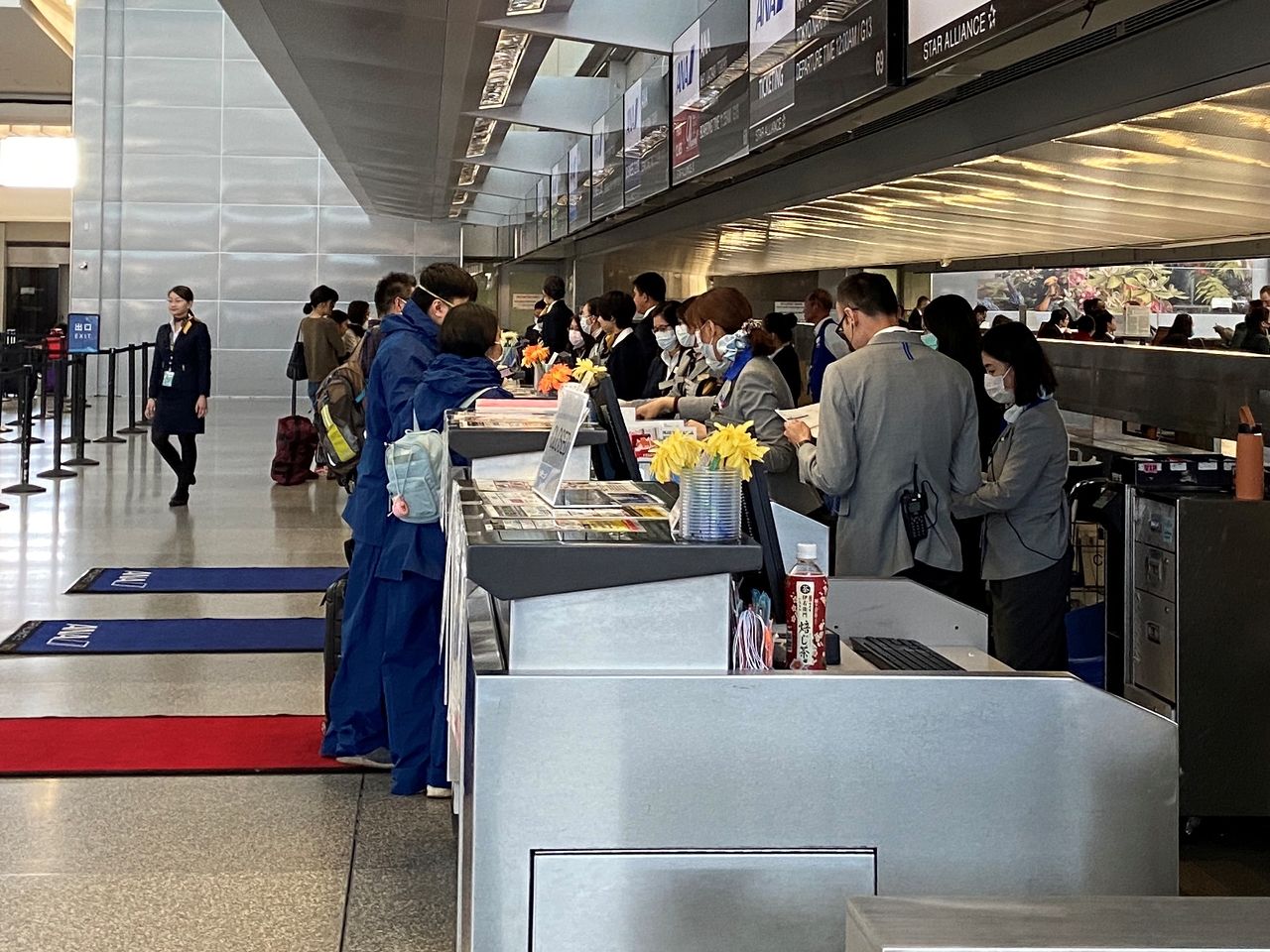 FILE PHOTO: Workers at the ticket desk for Japanese airline All Nippon Airways assist travellers at the departures hall of the San Francisco International Airport, during coronavirus disease (COVID-19) outbreak, in San Francisco, U.S., March 20, 2020. REUTERS/Stephen Nellis
