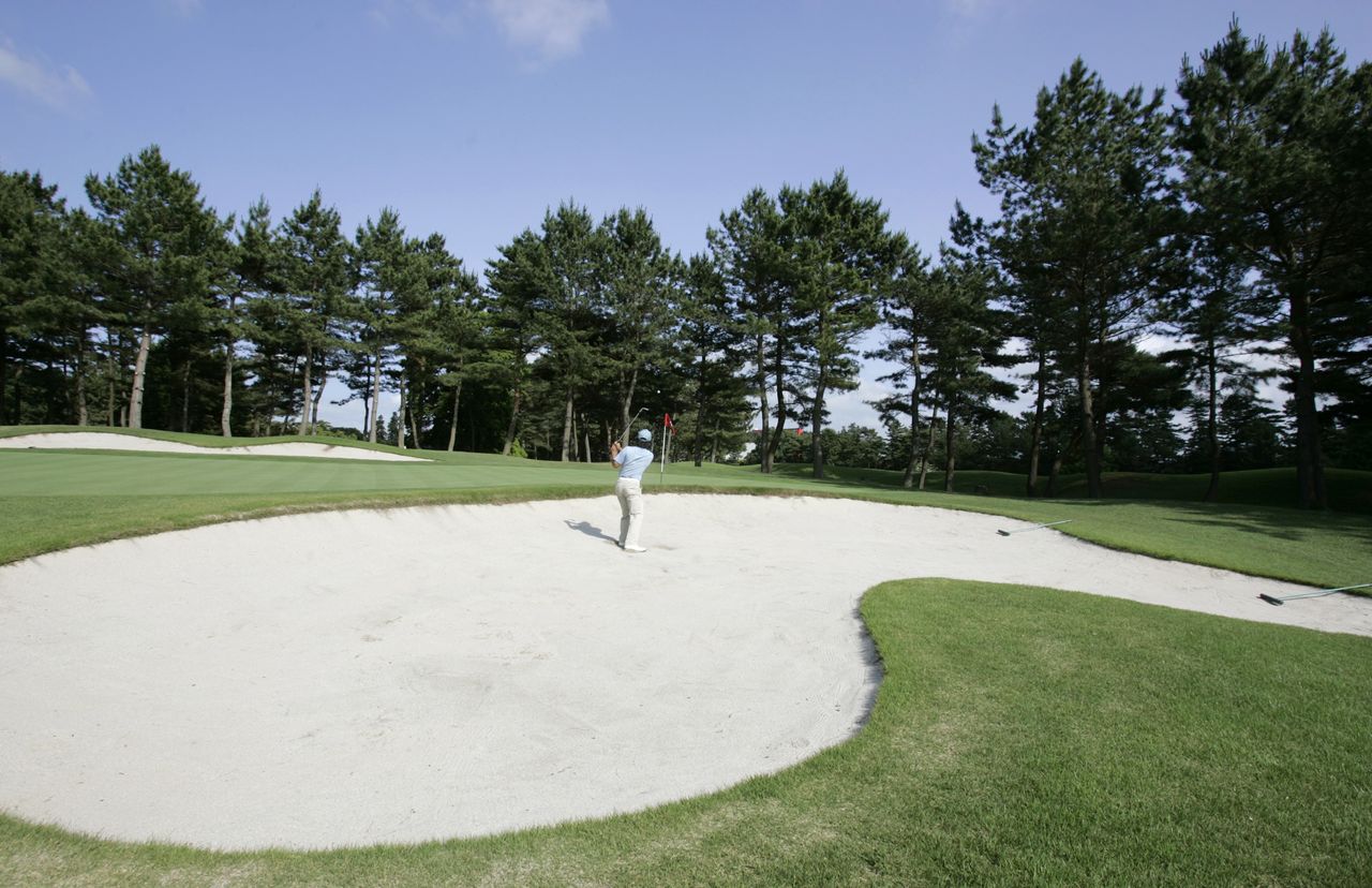 FILE PHOTO: A golfer blasts out from a bunker at Accordia Golf