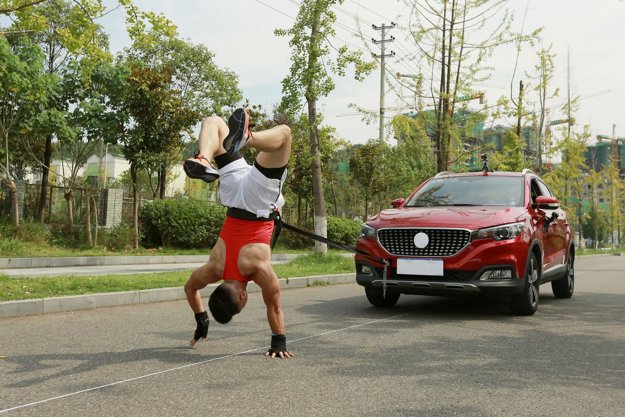 Zhang Shuang, 29, attempts to set a new Guinness World Record for "Fastest time to pull a car 50 metres walking on hands" in Nan Chong City, Sichuan Province, China September 25, 2021. Courtesy of Guinness World Records 2021/Chen Maochao/Handout via REUTERS