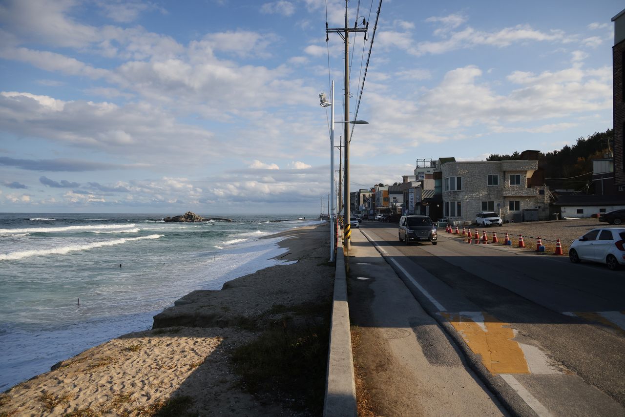 Houses, cafes and a concrete road are seen next to erosion-affected Sacheon beach where there used to be a long sand beach, in Gangneung, South Korea, November 3, 2021. REUTERS/Kim Hong-Ji