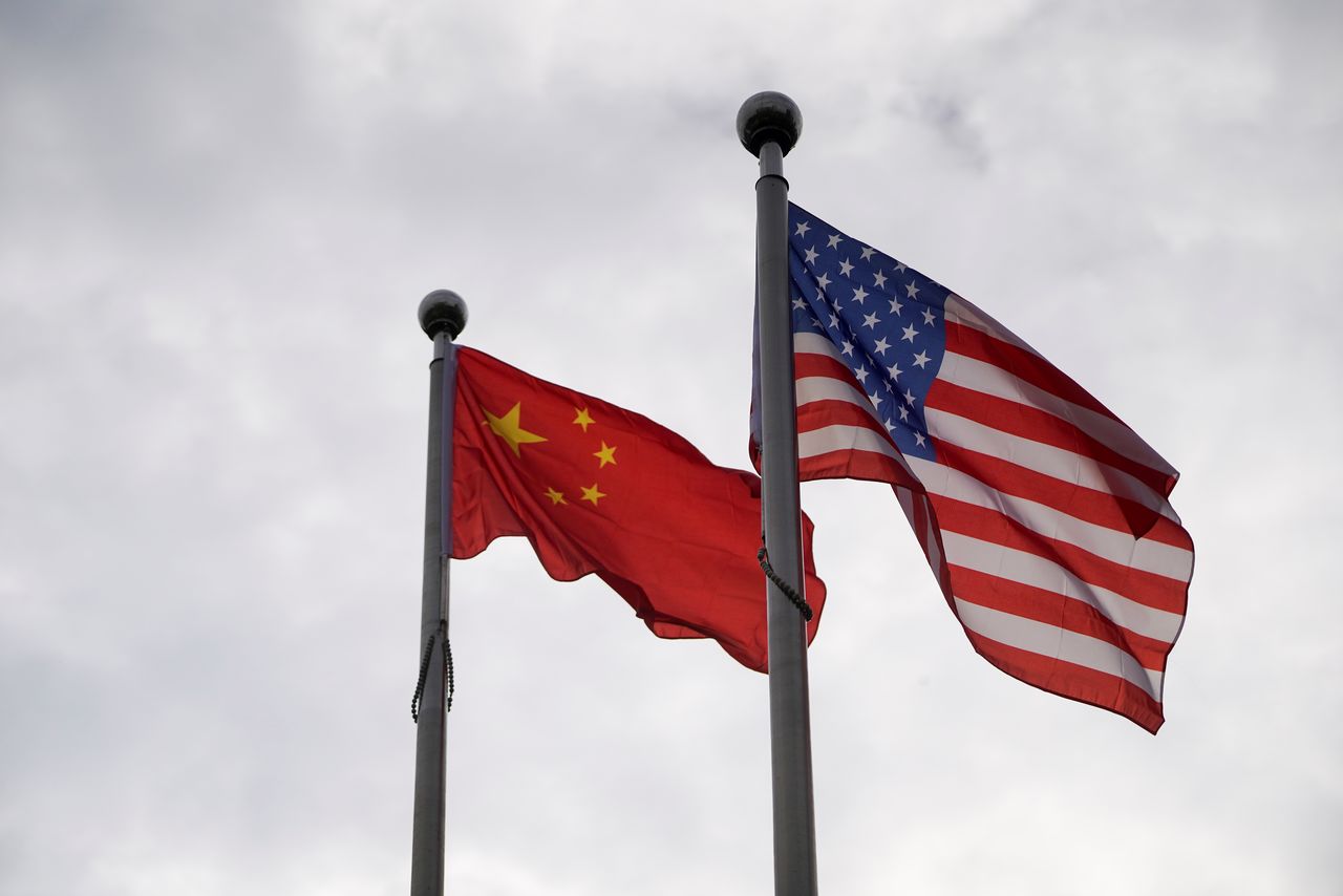 FILE PHOTO: Chinese and U.S. flags flutter outside a company building in Shanghai, China November 16, 2021. REUTERS/Aly Song/File Photo