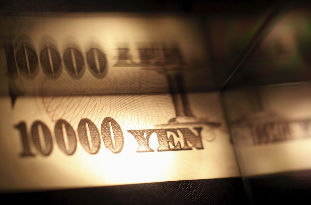Light is cast on a Japanese 10,000 yen note as it