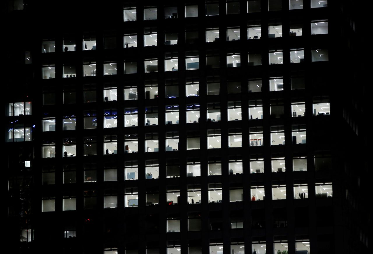 FILE PHOTO: Office lighting is seen through windows of a high-rise office building in Tokyo July 31, 2014. REUTERS/Issei Kato/File Photo