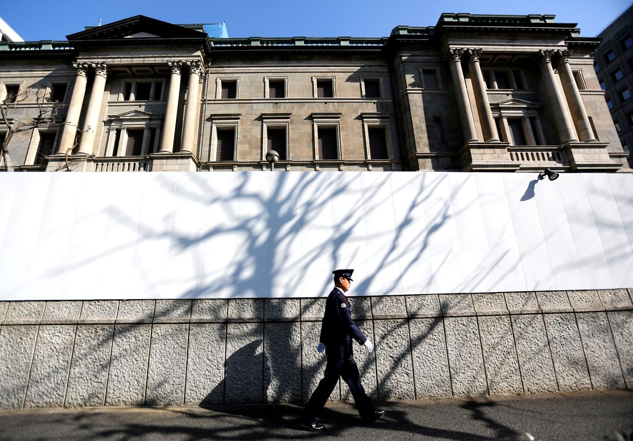 FILE PHOTO: A security guard walks past in front of the Bank of Japan headquarters in Tokyo, Japan January 23, 2019. REUTERS/Issei Kato/File Photo