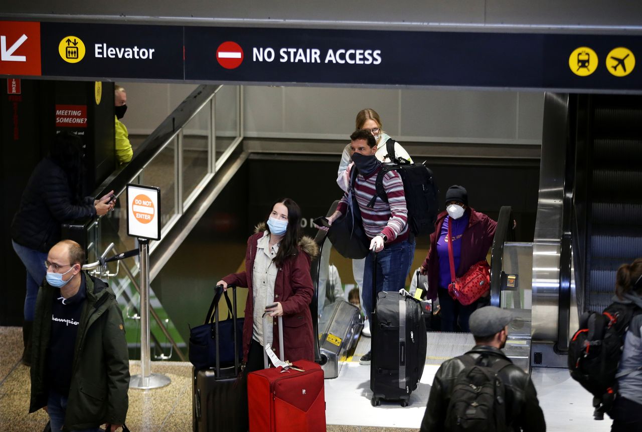 FILE PHOTO: People enter the baggage claim area from the international arrivals terminal as the U.S. reopens air and land borders to coronavirus disease (COVID-19) vaccinated travellers for the first time since the COVID-19 restrictions were imposed, at Sea-Tac Airport in Seattle, Washington, U.S. November 8, 2021.  REUTERS/Lindsey Wasson