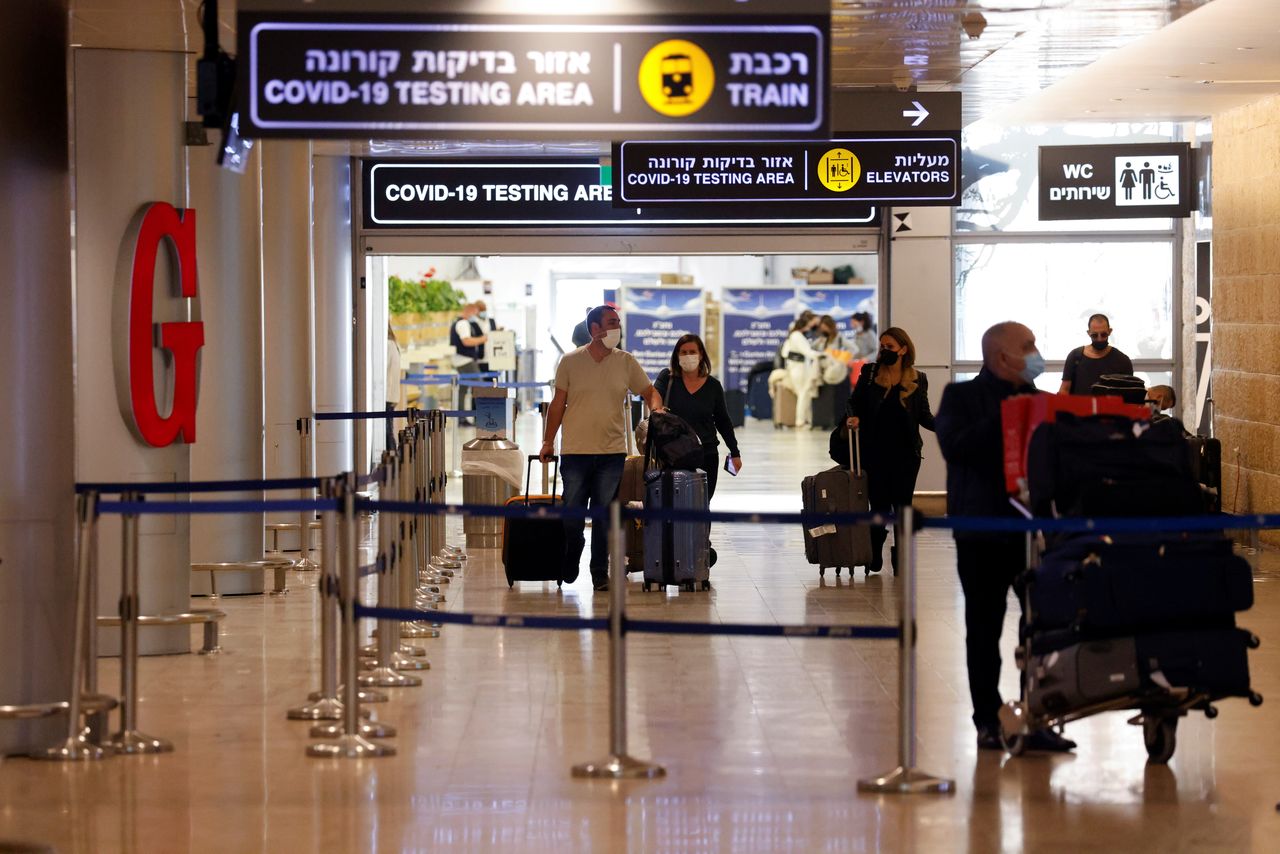 FILE PHOTO: Travellers exit the coronavirus testing area at Ben Gurion International Airport as Israel imposes new restrictions near Tel Aviv, Israel, November 28, 2021. REUTERS/Amir Cohen/File Photo