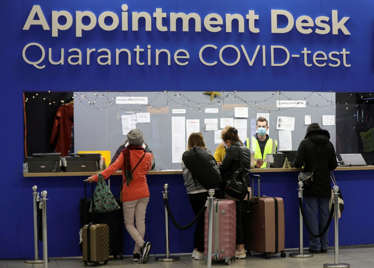 People wait in front of an "Appointment Desk" for quarantine and coronavirus disease (COVID-19) test appointments inside Schiphol Airport, after Dutch health authorities said that 61 people who arrived in Amsterdam on flights from South Africa tested positive for COVID-19, in Amsterdam, Netherlands, November 27, 2021. REUTERS/Eva Plevier/File Photo