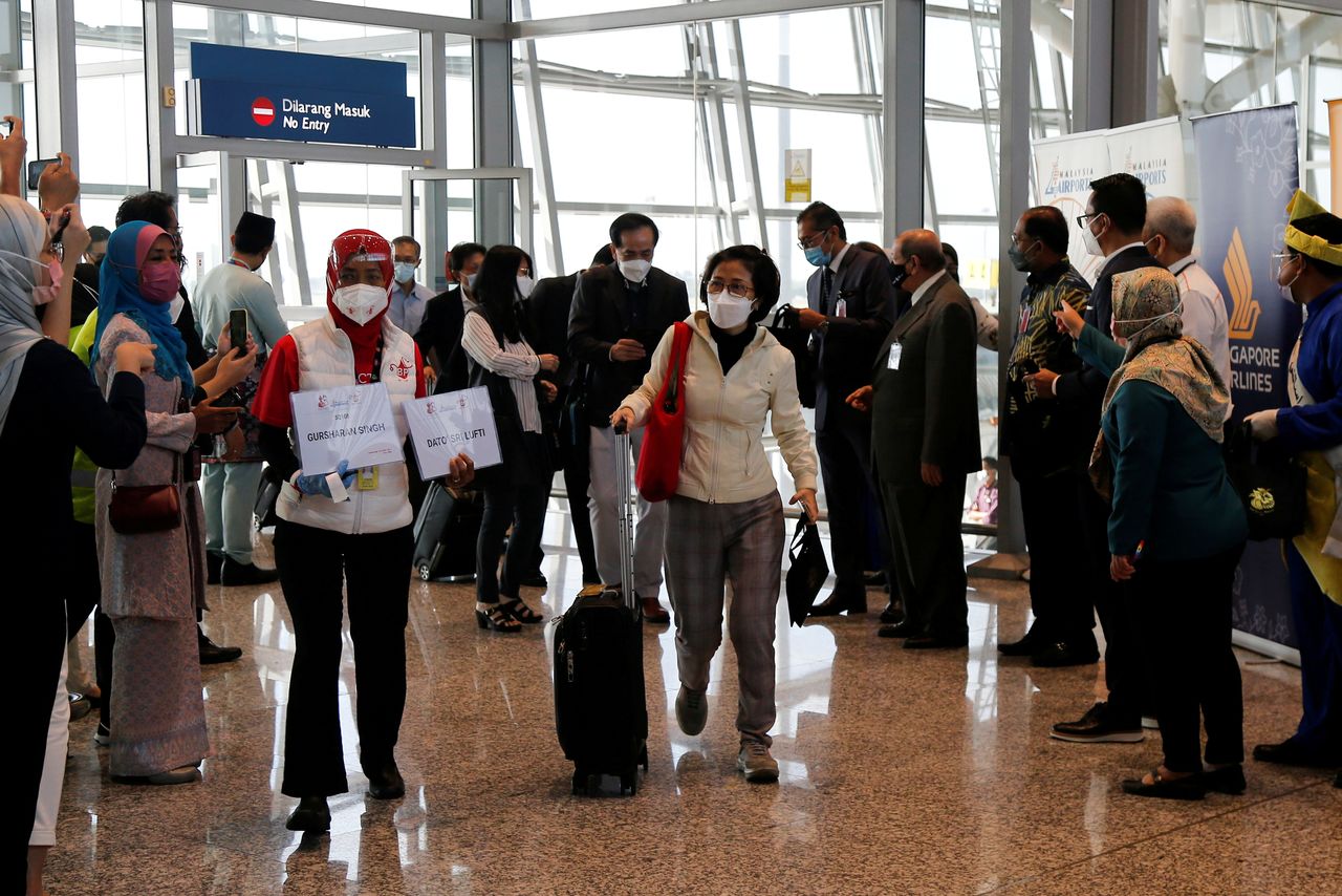 Travellers arrive at Kuala Lumpur International Airport (KLIA) under Malaysia-Singapore Vaccinated Travel Lane (VTL) programme, after travel between the two countries was halted due to the coronavirus disease (COVID-19) pandemic, in Sepang, Malaysia November 29, 2021. REUTERS/Lai Seng Sin