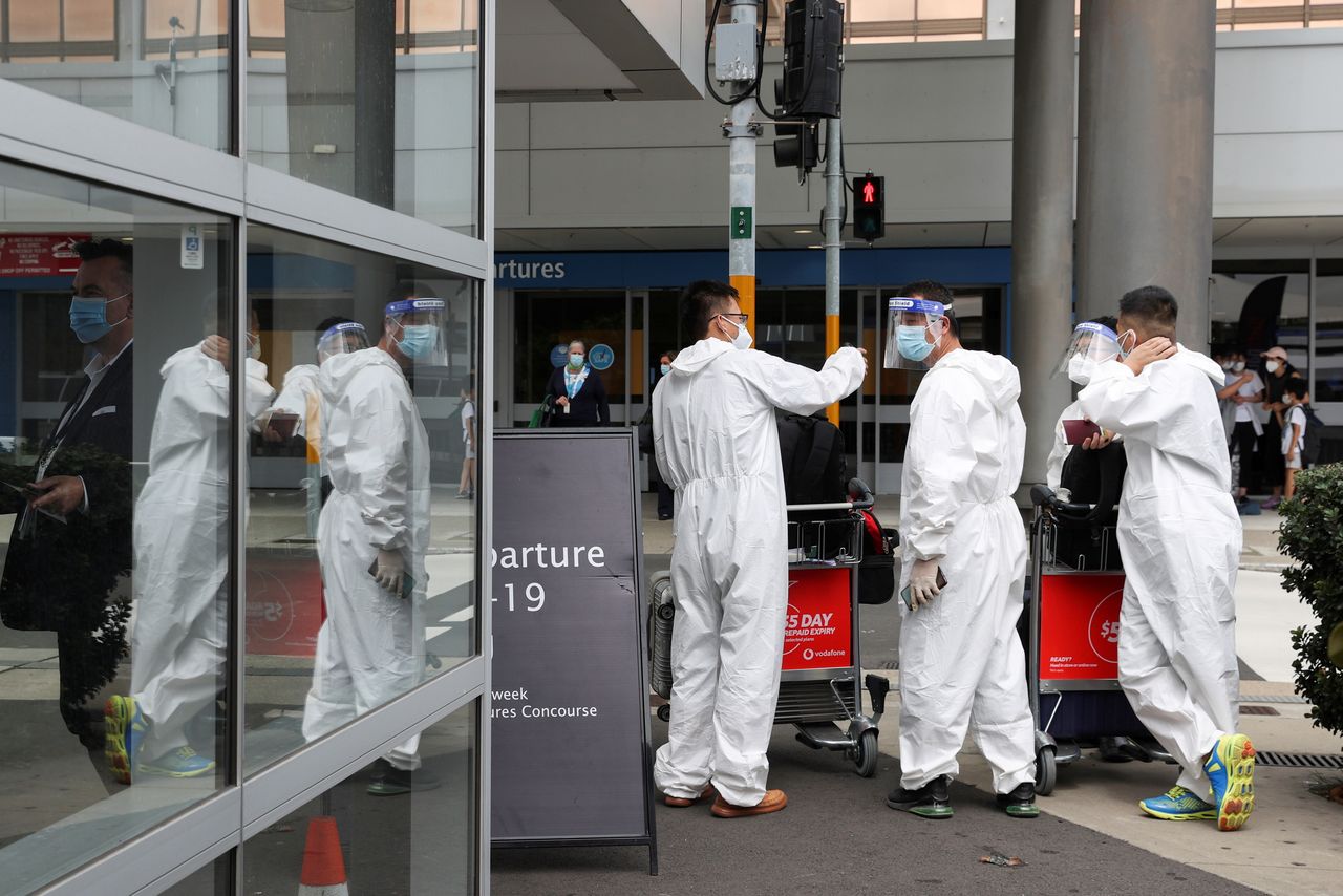 Travellers wear personal protective equipment outside the international terminal at Sydney Airport, as countries react to the new coronavirus Omicron variant amid the coronavirus disease (COVID-19) pandemic, in Sydney, Australia, November 29, 2021. REUTERS/Loren Elliott