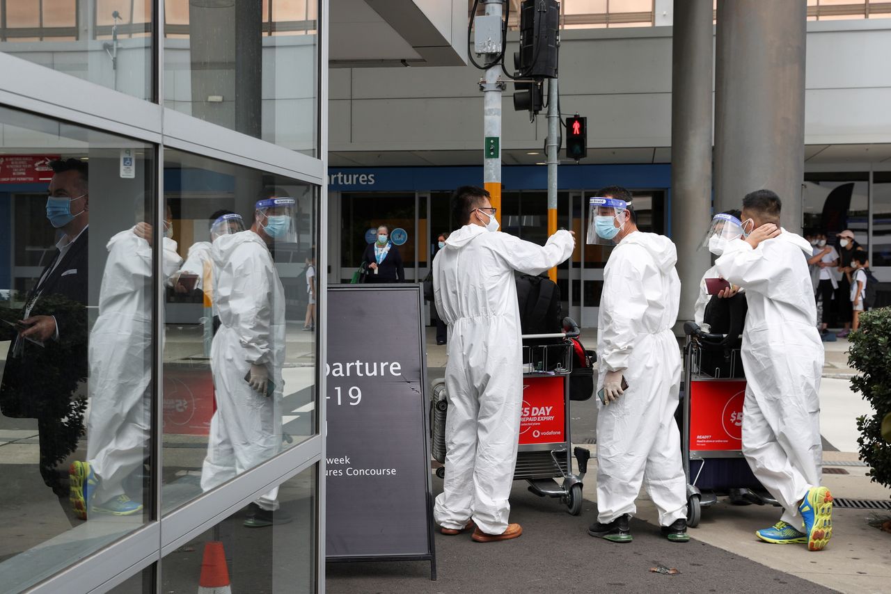 Travellers wear personal protective equipment outside the international terminal at Sydney Airport, as countries react to the new coronavirus Omicron variant amid the coronavirus disease (COVID-19) pandemic, in Sydney, Australia, November 29, 2021.  REUTERS/Loren Elliott
