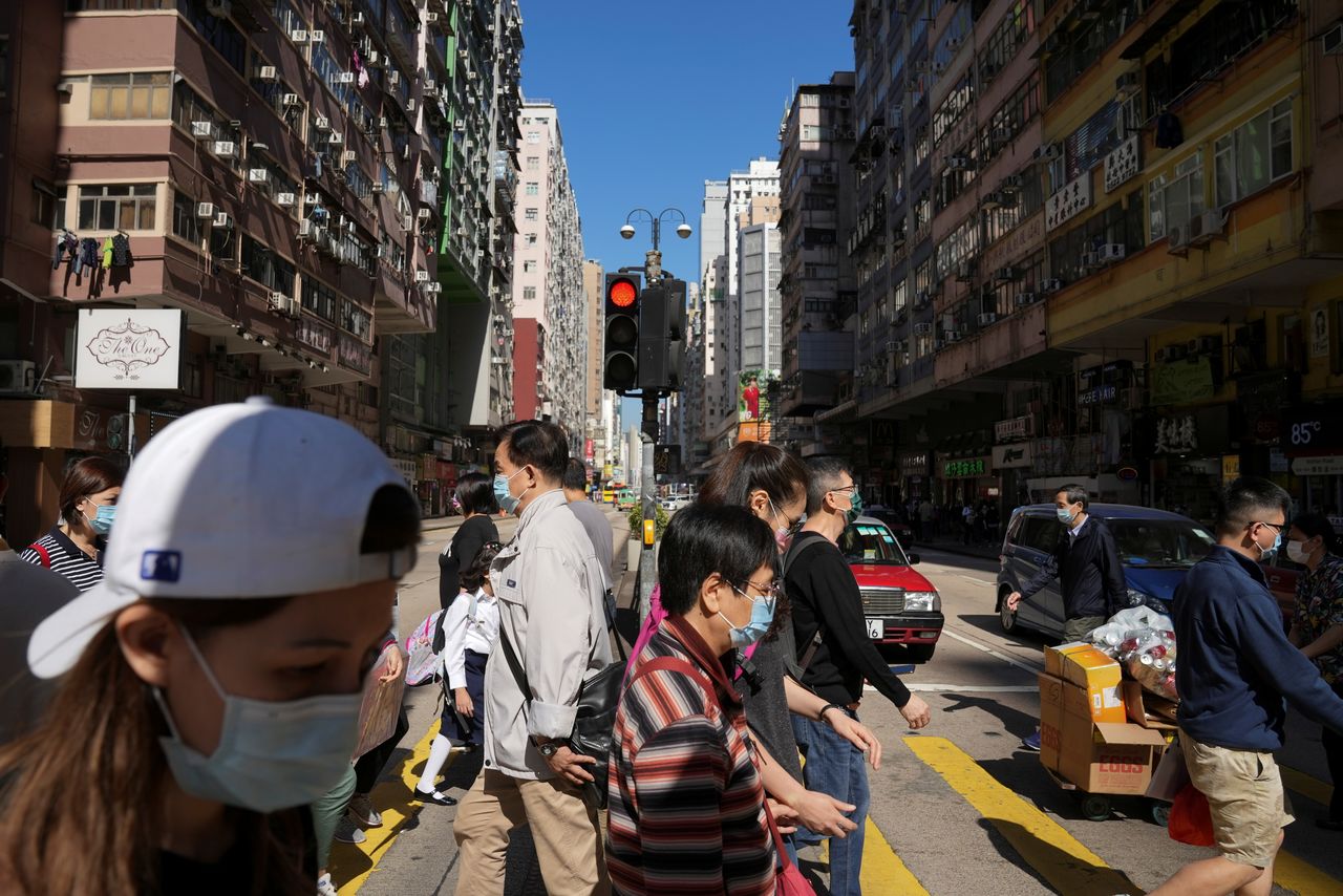 People wearing face masks to prevent the spread of the coronavirus disease (COVID-19), walk on a street in Hong Kong, China November 29, 2021. REUTERS/Lam Yik/file photo