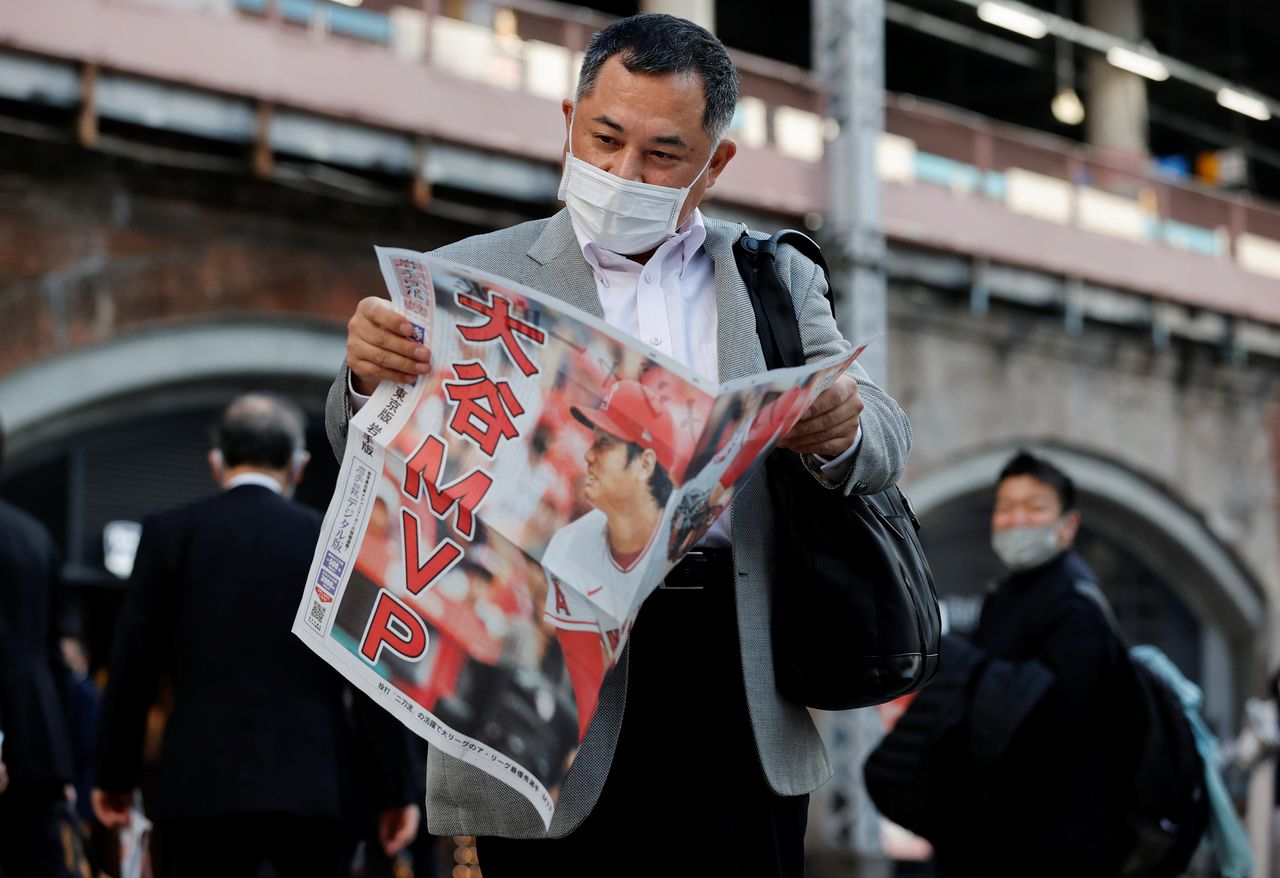 FILE PHOTO: A man reads an extra edition of a newspaper, reporting Japan