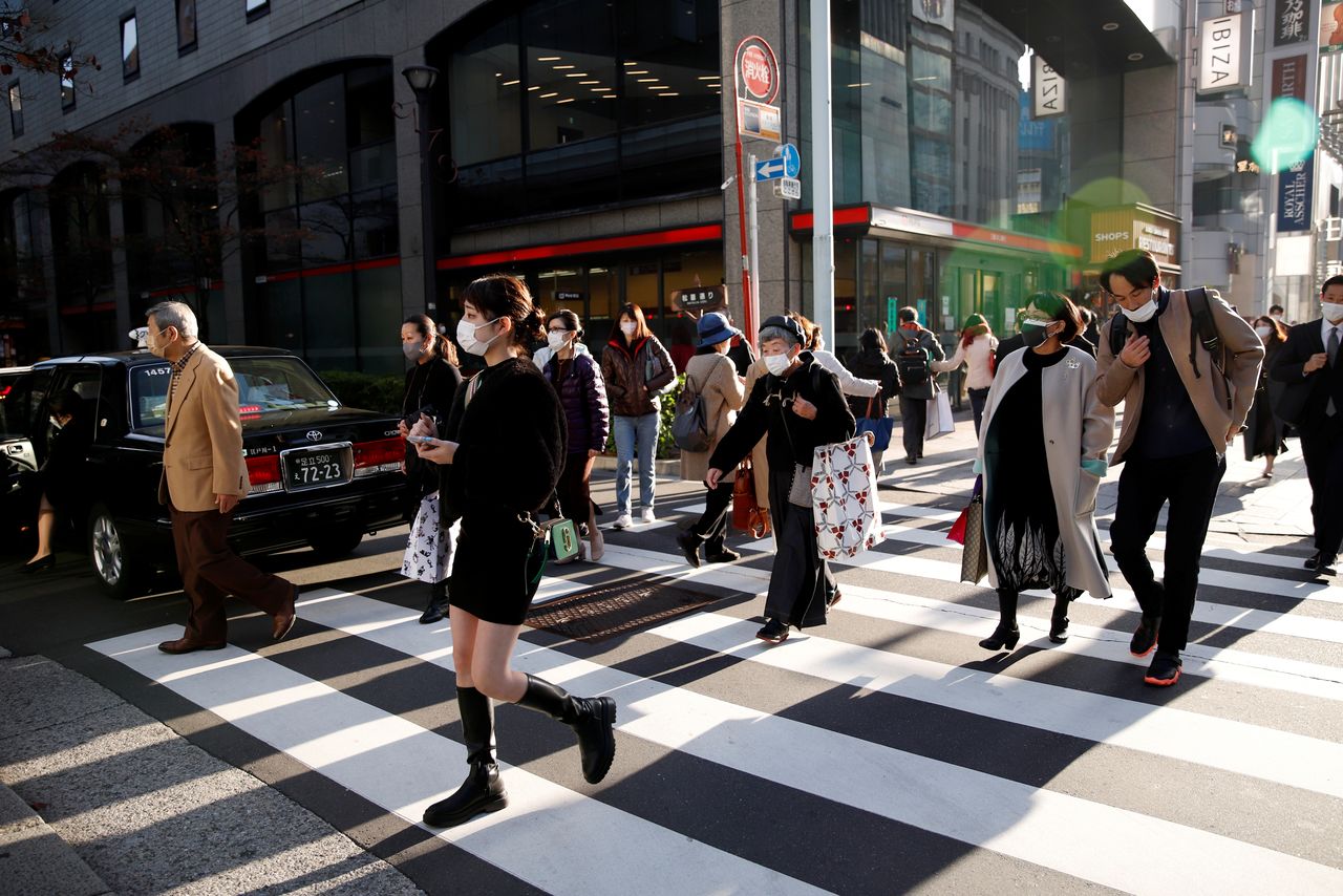People cross the street in the Ginza shopping area, on the first day of Japan