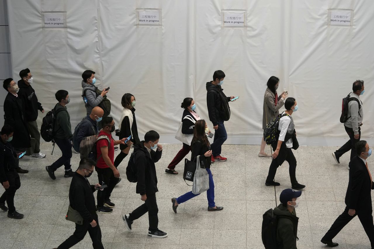 Passengers wearing masks to prevent the spread of the coronavirus disease (COVID-19), walk at a subway station in Hong Kong, China December 1, 2021. REUTERS/Lam Yik