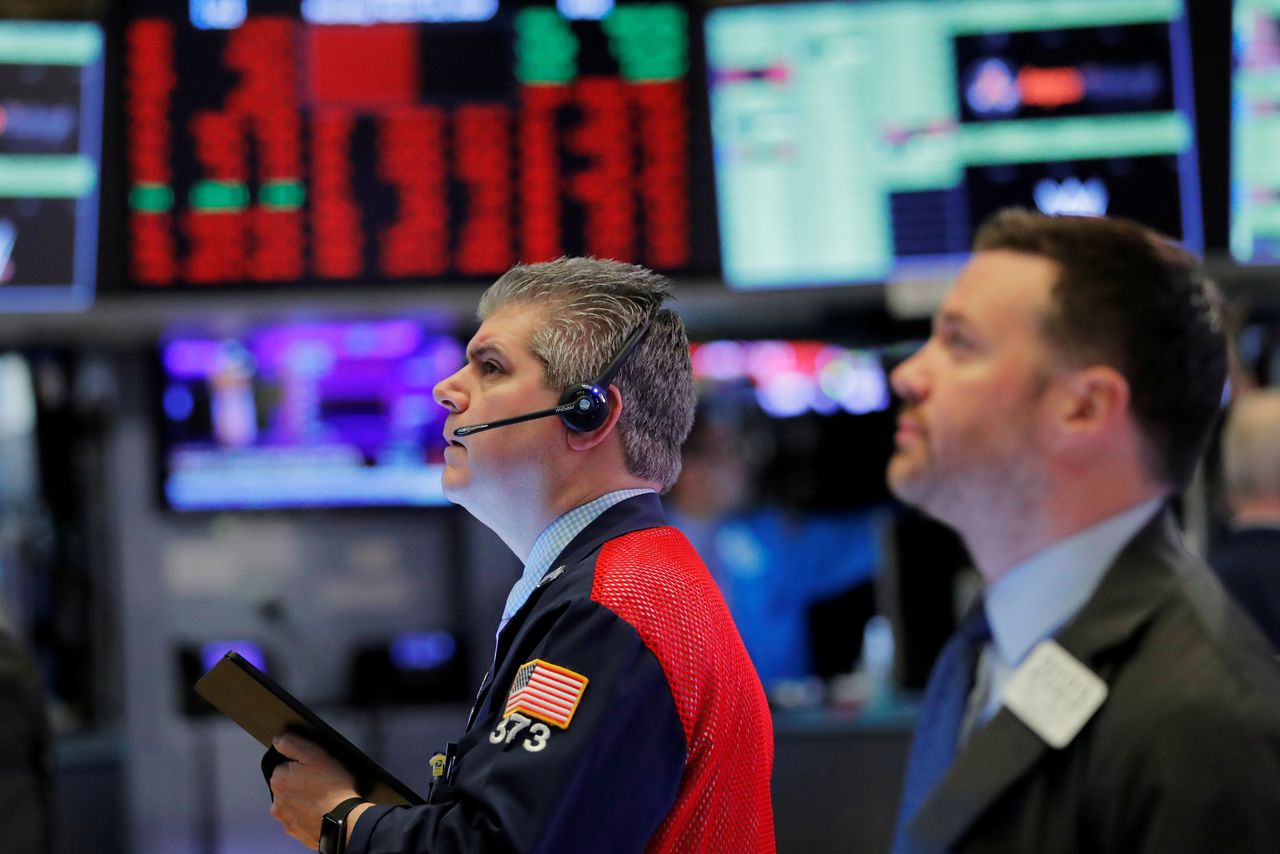 FILE PHOTO: Traders work on the floor of the New York Stock Exchange shortly after the opening bell as trading is halted in New York, U.S., March 16, 2020. REUTERS/Lucas Jackson