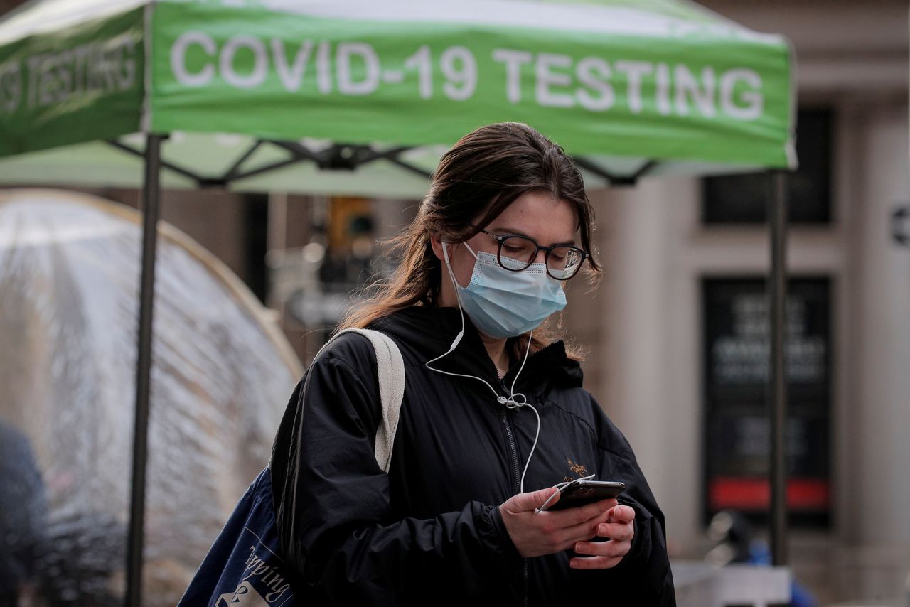 A woman uses her phone outside a coronavirus disease (COVID-19) sidewalk testing site in New York, U.S., December 1, 2021.  REUTERS/Brendan McDermid