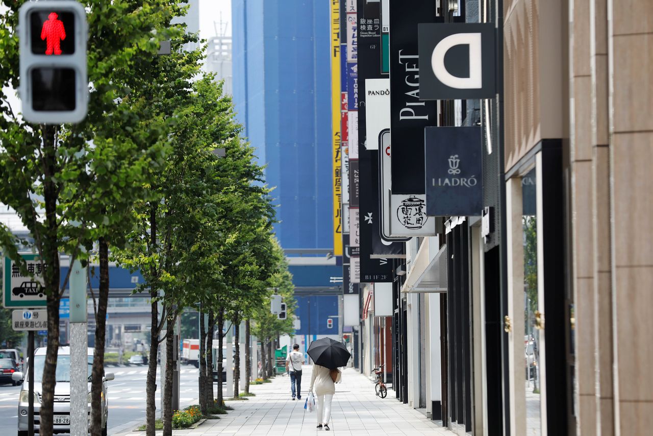 A woman walks past at a shopping district, amid the coronavirus disease (COVID-19) pandemic in Tokyo, Japan August 17, 2020. REUTERS/Kim Kyung-Hoon/File Photo