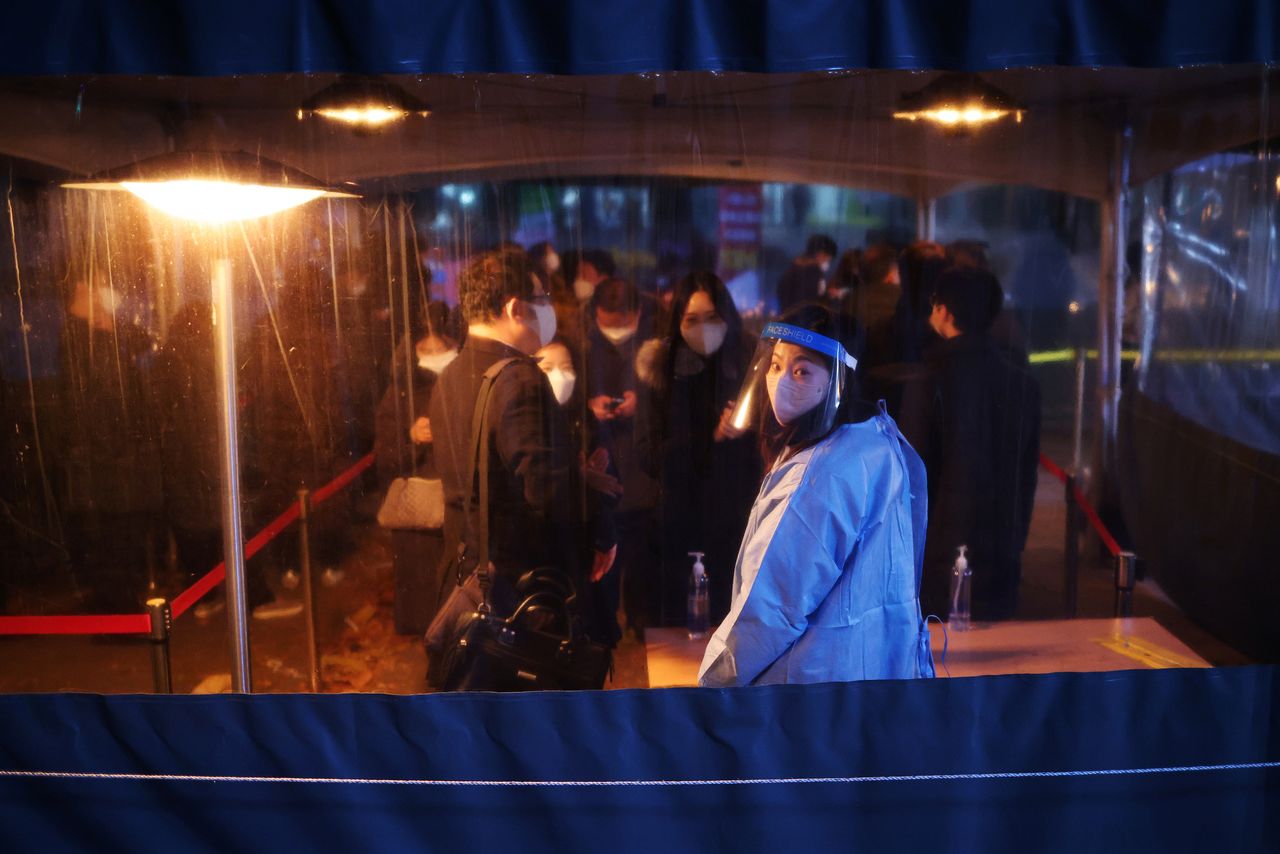 FILE PHOTO: People wait in a line to undergo coronavirus disease (COVID-19) test at its testing site in central Seoul, South Korea, December 1, 2021.    REUTERS/Kim Hong-Ji