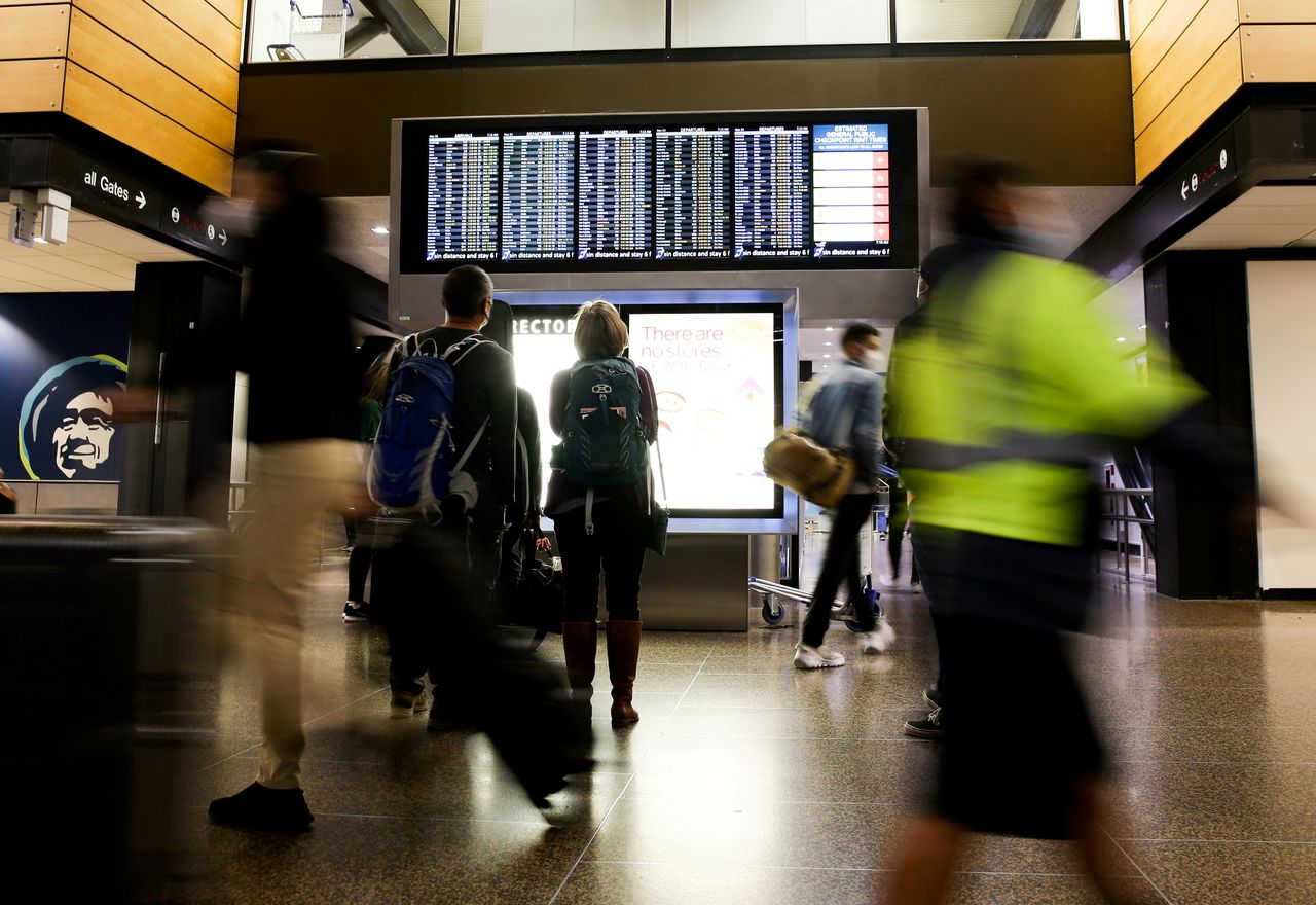 FILE PHOTO: Travellers check a departures list at the ticketing level of Seattle-Tacoma International Airport before the Thanksgiving holiday in Seattle, Washington, U.S. November 24, 2021. REUTERS/Lindsey Wasson/File Photo/File Photo