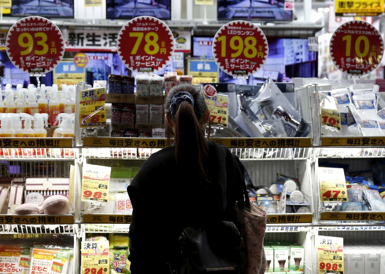 FILE PHOTO: A woman looks at items outside an outlet store at a shopping district in Tokyo, Japan, February 25, 2016. REUTERS/Yuya Shino/File Photo