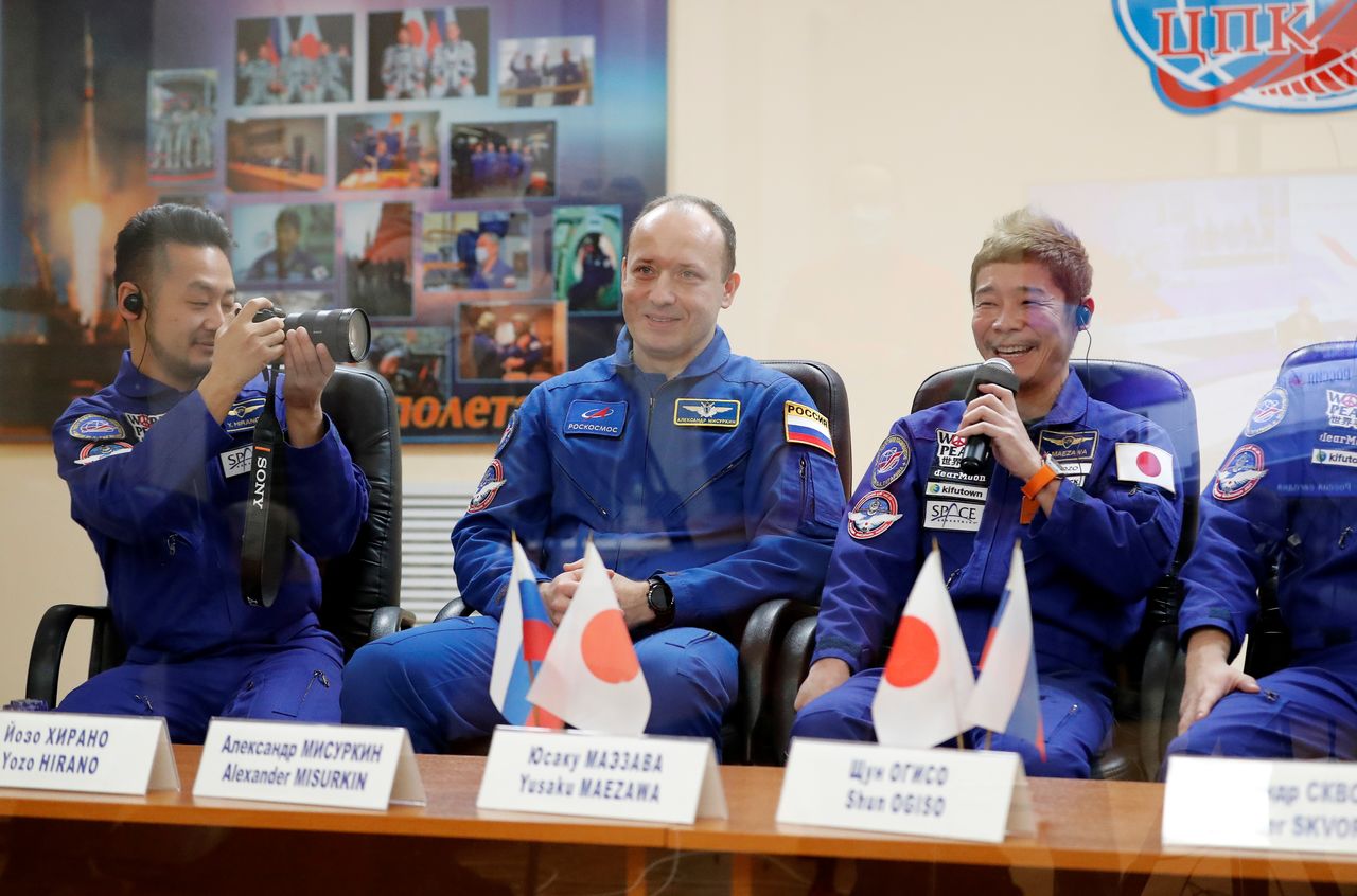 Roscosmos cosmonaut Alexander Misurkin and space flight participants, Japanese entrepreneur Yusaku Maezawa and his production assistant Yozo Hirano, sit behind a glass wall during a news conference in Baikonur, Kazakhstan December 7, 2021. The mission to the International Space Station (ISS) is scheduled for December 8, 2021. REUTERS/Shamil Zhumatov/Pool