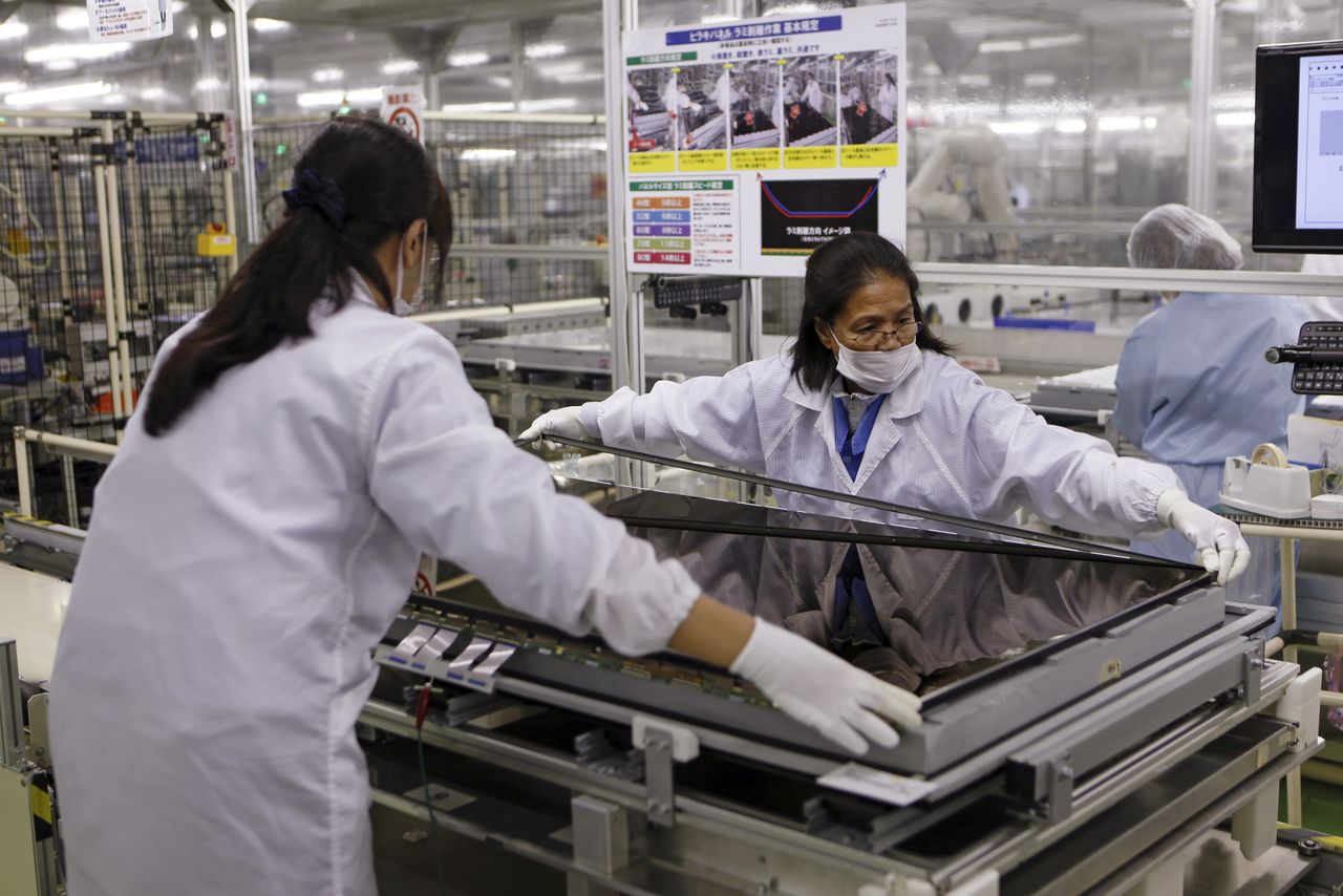 FILE PHOTO: Women assemble an Aquos television at Sharp Corp