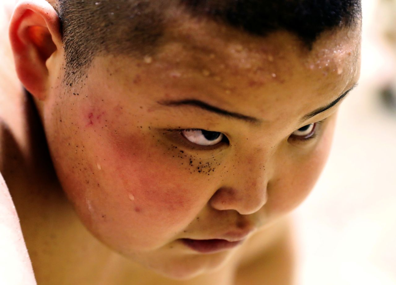 FILE PHOTO: Elementary school sumo wrestler Kyuta Kumagai, with sand on his face from a sumo ring, practises ahead of  the All-Japan Elementary School Sumo Championship at Komatsuryu sumo club in Tokyo, Japan, December 1, 2021. REUTERS/Kim Kyung-Hoon