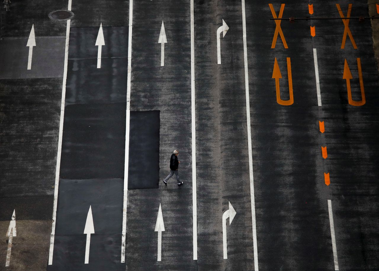 A man walks on an empty road, amid the coronavirus disease (COVID-19) pandemic, in Tokyo, Japan December 8, 2021. REUTERS/Issei Kato