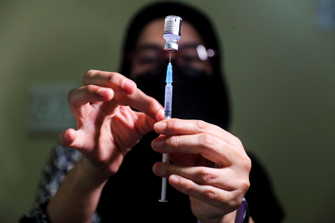 FILE PHOTO: A pharmacist prepares a dose of the coronavirus disease (COVID-19) Pfizer vaccine amidst the spread of the SARS-CoV-2 variant Omicron in Johannesburg, South Africa, December 04, 2021.  REUTERS/Sumaya Hisham
