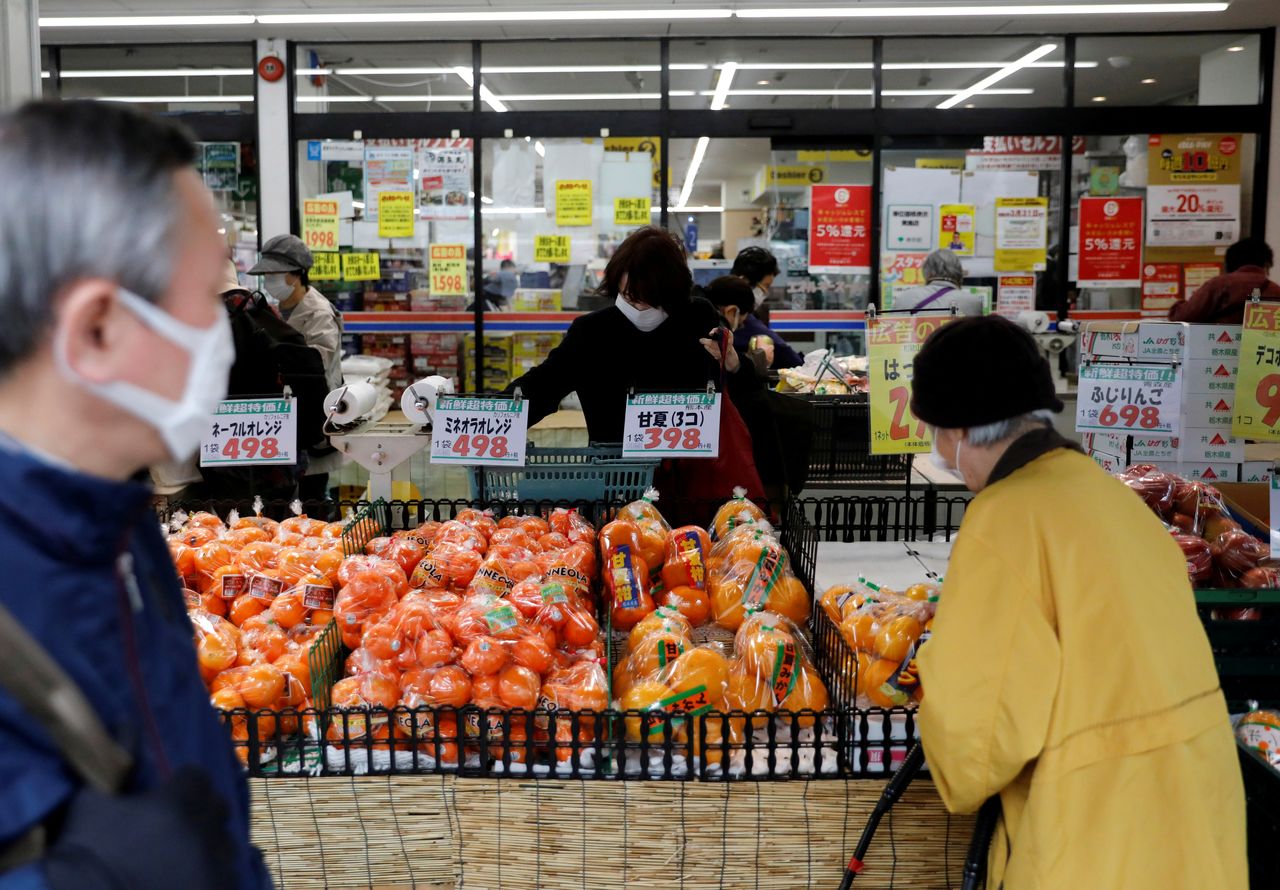 FILE PHOTO: Shoppers wearing protective face masks, following an outbreak of the coronavirus disease (COVID-19), are seen at a supermarket in Tokyo, Japan March 27, 2020. REUTERS/Issei Kato/File Photo GLOBAL BUSINESS WEEK AHEAD