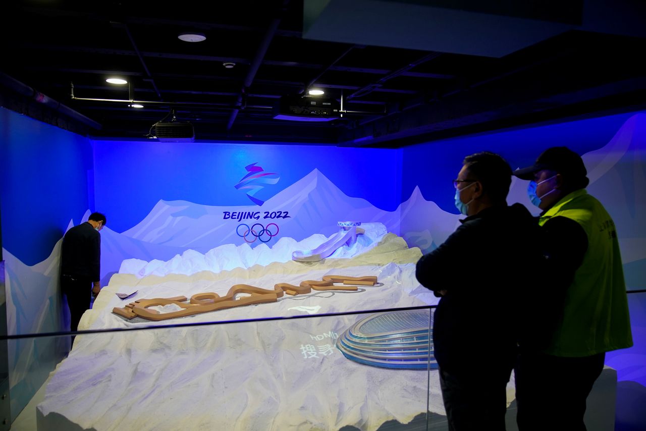 Staff members work near the emblem for Beijing 2022 Winter Olympics displayed at the Shanghai Sports Museum in Shanghai, China, December 8, 2021. REUTERS/Aly Song