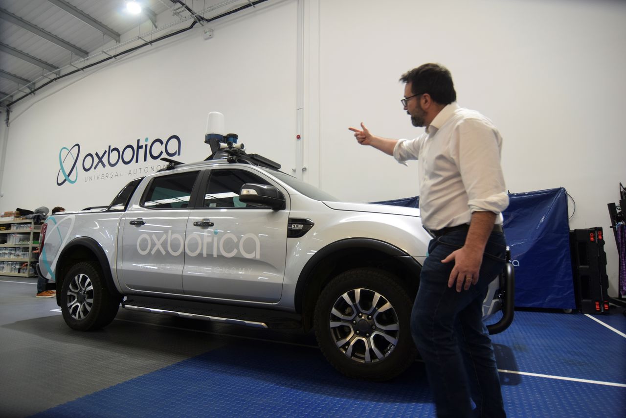 Paul Newman, founder of British autonomous vehicle software startup Oxbotica, speaks next to a converted pickup truck that has been used for test self-driving operations with a mining company, in Oxford, Britain, October 22, 2021. EUTERS/Nick Carey