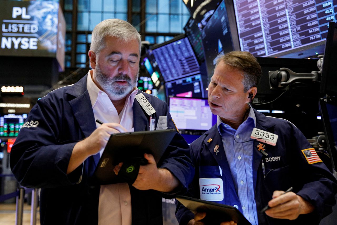 FILE PHOTO: Traders work on the floor of the New York Stock Exchange (NYSE) in New York City, U.S., December 8, 2021.  REUTERS/Brendan McDermid