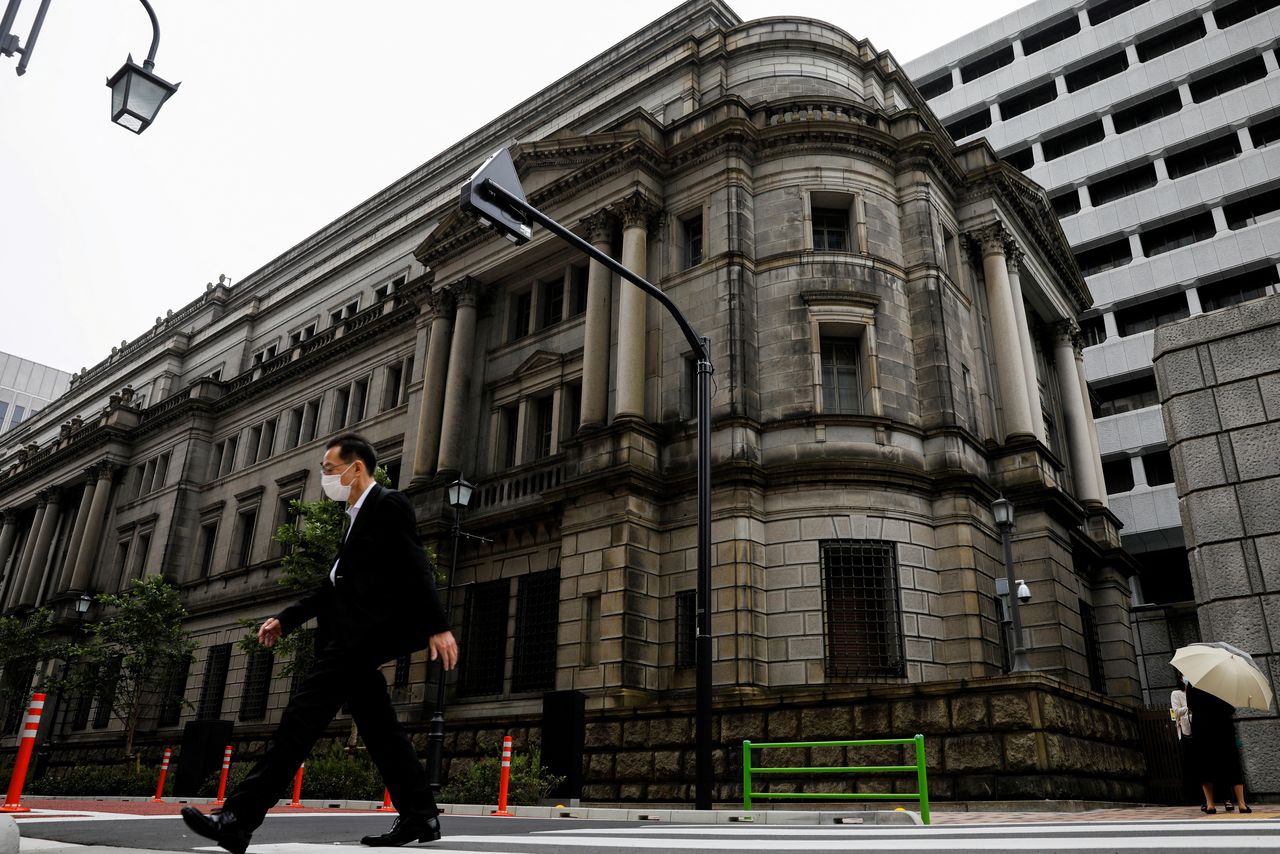 FILE PHOTO: A man wearing a protective mask walks past the headquarters of Bank of Japan amid the coronavirus disease (COVID-19) outbreak in Tokyo, Japan, May 22, 2020.REUTERS/Kim Kyung-Hoon/File Photo