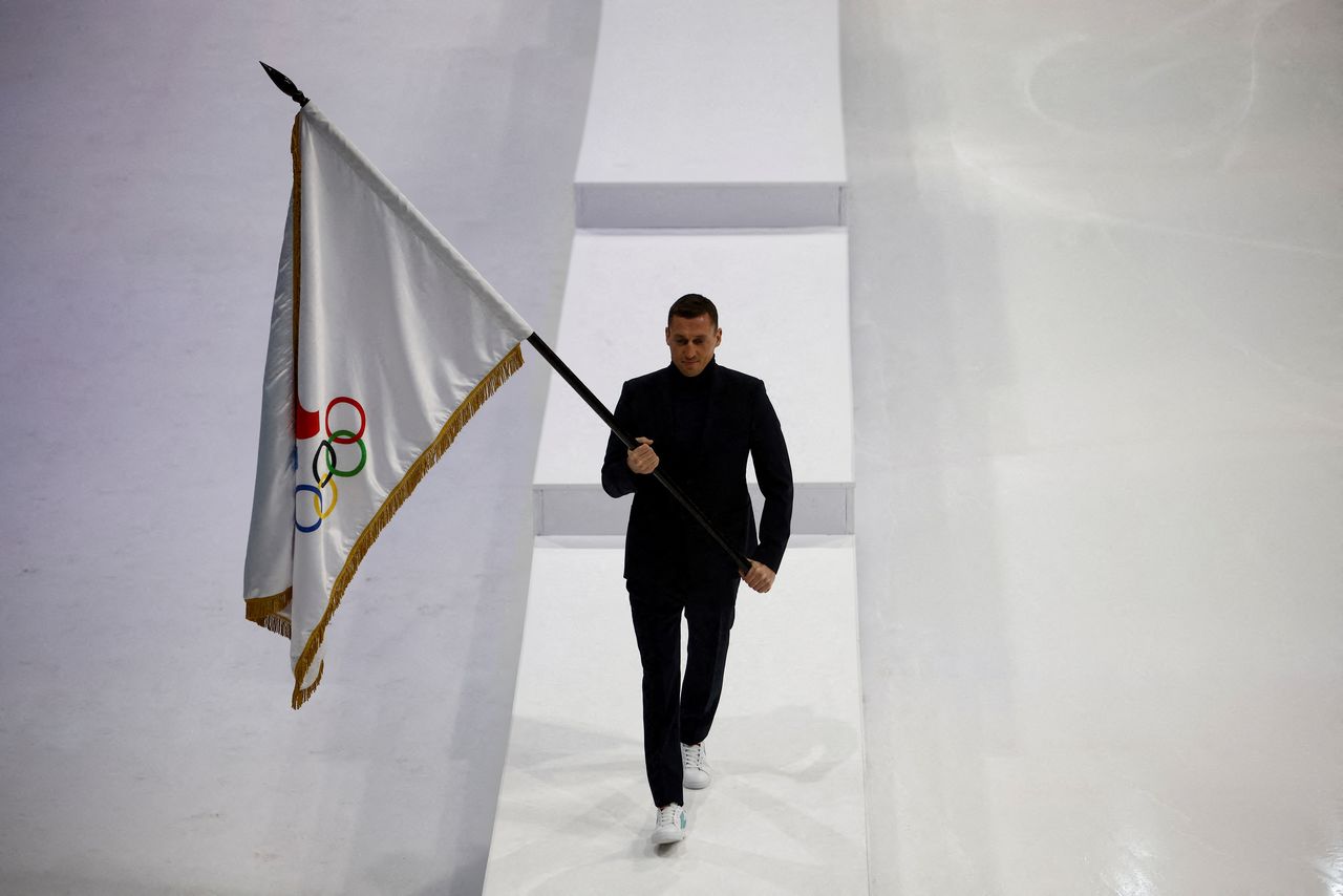 Retired Russian cross-country skier Alexander Legkov carries the flag of the Russian Olympic Committee during the presentation of uniforms for Russian athletes competing in the 2022 Winter Olympics in Beijing, in Moscow, Russia December 10, 2021. REUTERS/Maxim Shemetov