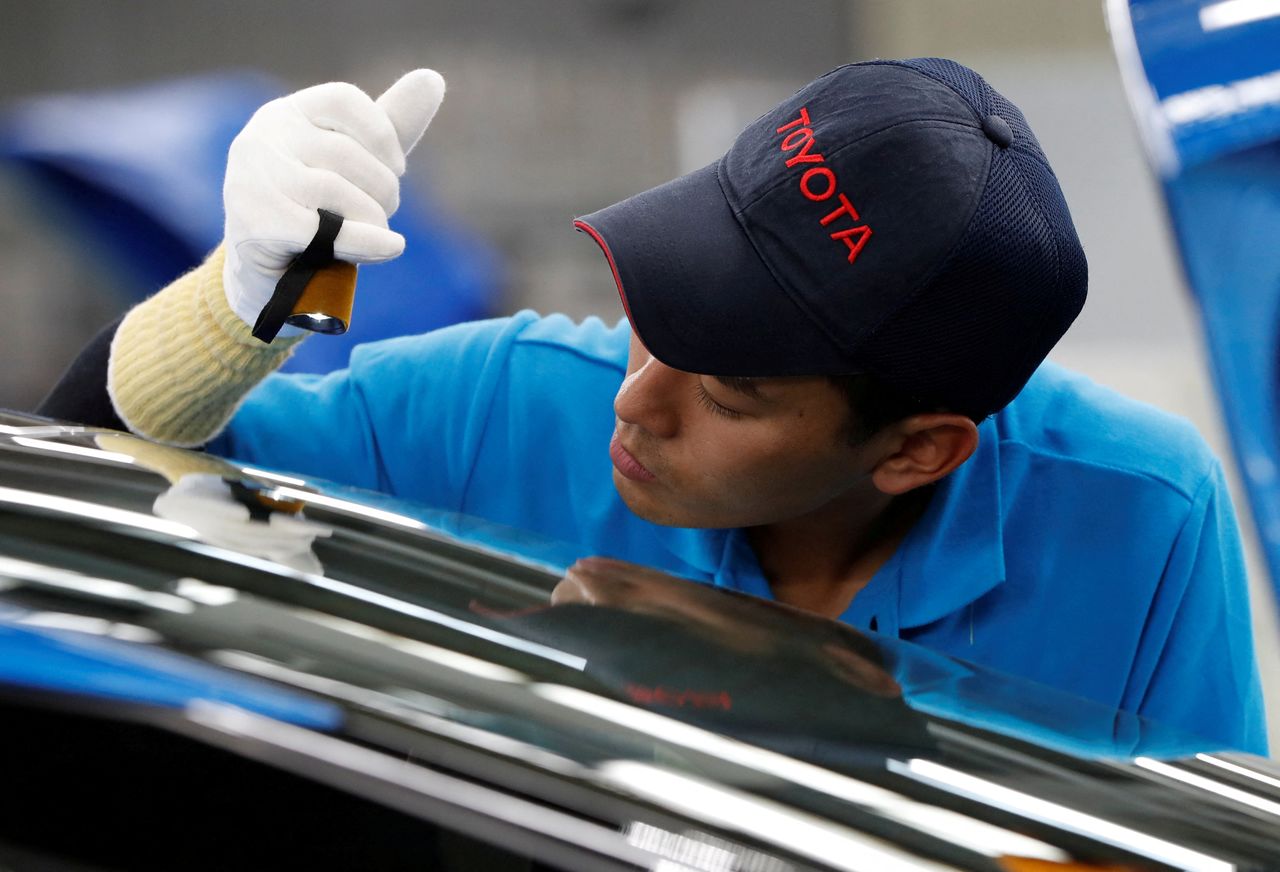 FILE PHOTO: An employee of Toyota Motor Corp. works on the assembly line of Mirai fuel cell vehicle (FCV) at the company
