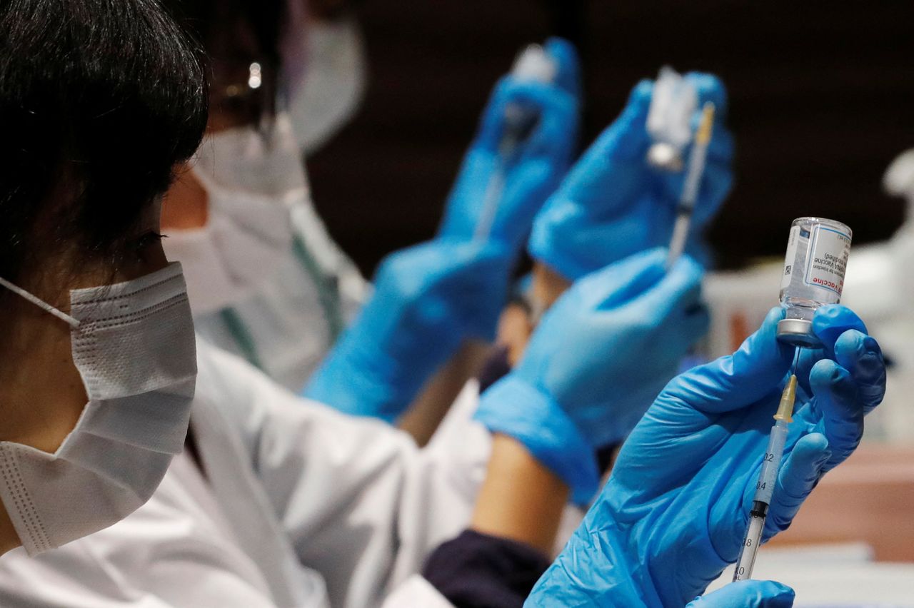 FILE PHOTO: Healthcare workers prepare doses of the Moderna coronavirus disease (COVID-19) vaccine before administering them to staffers of Japan