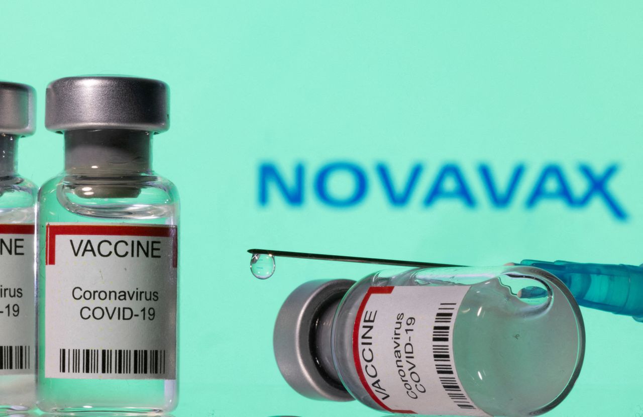 FILE PHOTO: Vials labelled "VACCINE Coronavirus COVID-19" and a syringe are seen in front of a displayed Novavax logo in this illustration taken December 11, 2021. REUTERS/Dado Ruvic/Illustration