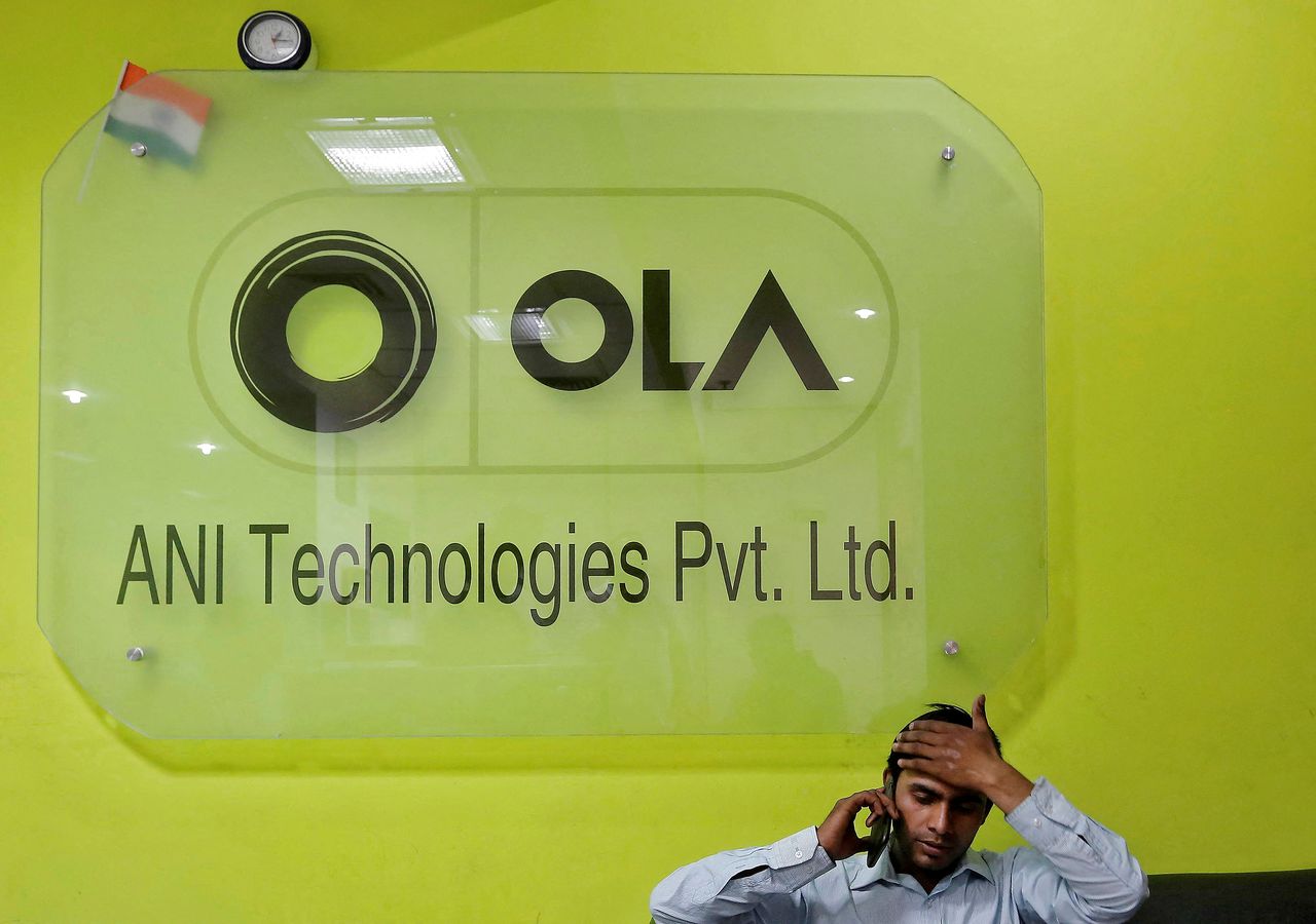 FILE PHOTO: An employee speaks over his phone as he sits at the front desk inside the office of Ola cab service in Gurugram, previously known as Gurgaon, on the outskirts of New Delhi, India, April 20, 2016.  REUTERS/Anindito Mukherjee/File Photo