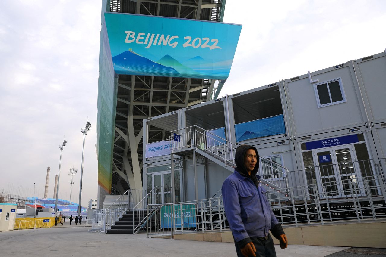 A worker walks under the Big Air Shougang, a competition venue for freestyle skiing and snowboard at the Beijing 2022 Winter Olympics, during an organised media tour, in Beijing, China December 15, 2021. REUTERS/Tingshu Wang