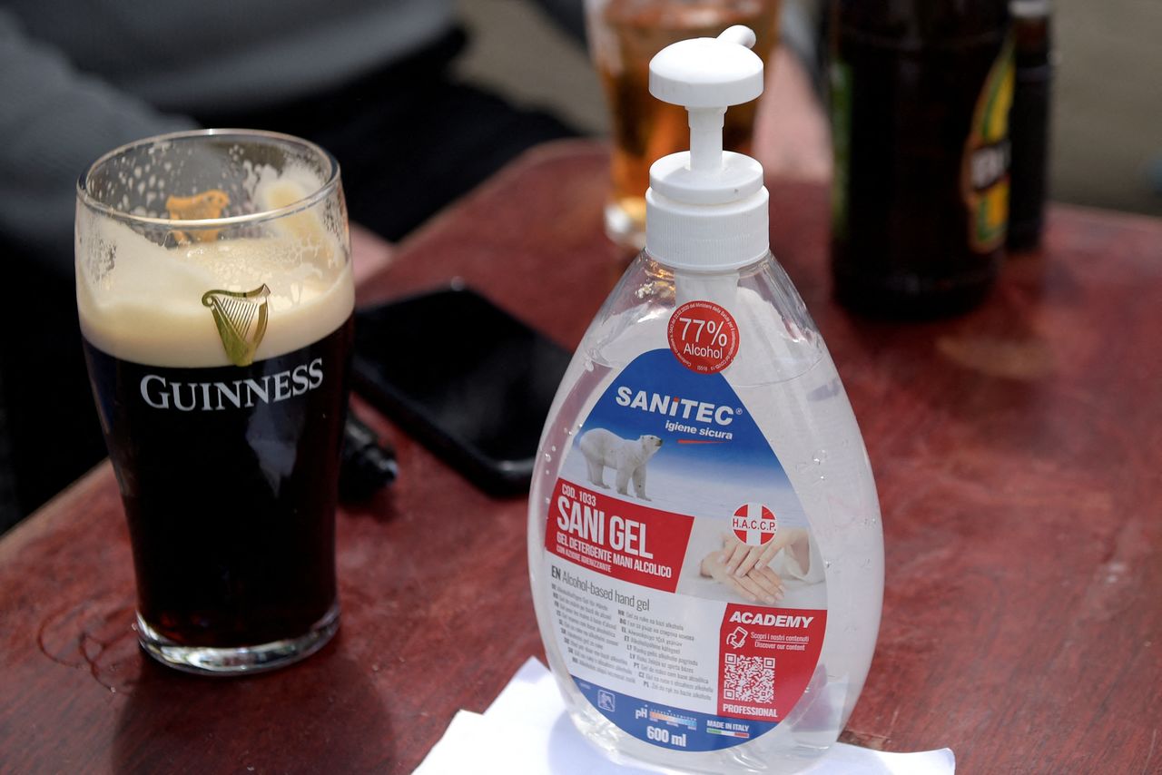 FILE PHOTO: A bottle of hand sanitizer is seen beside a pint of Guinness in Galway, Ireland, June 7, 2021. REUTERS/Clodagh Kilcoyne