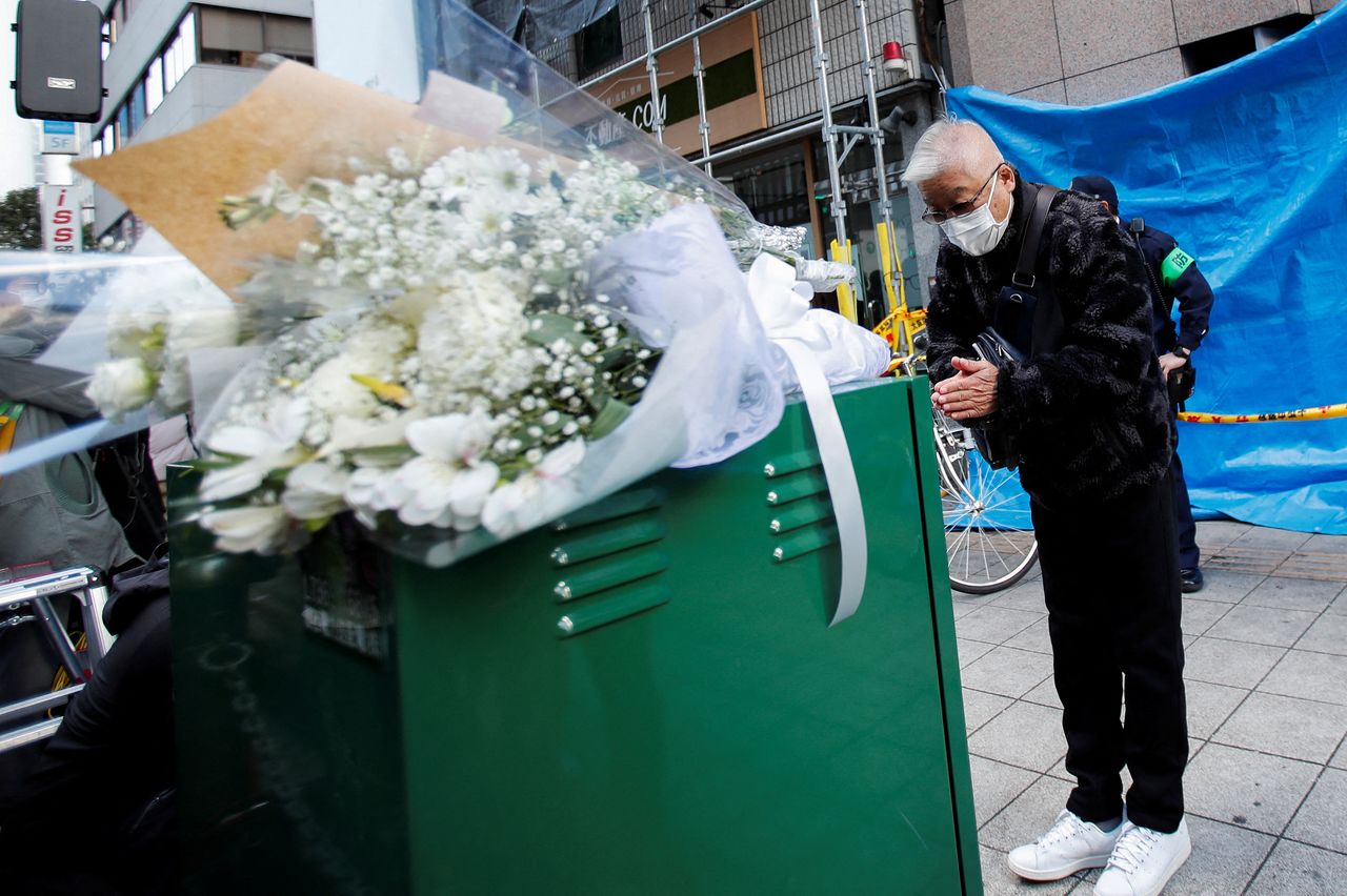 A man bows as he mourns for the victims in front of a building where a fire broke out, in Osaka, Japan December 18, 2021. REUTERS/Kim Kyung-Hoon