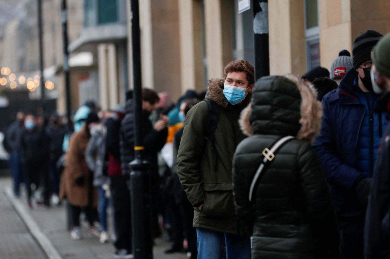 FILE PHOTO: People queue for their booster dose outside a coronavirus disease (COVID-19) mobile vaccination unit at Newcastle Quayside in Newcastle, Britain, December 19, 2021. REUTERS/Lee Smith