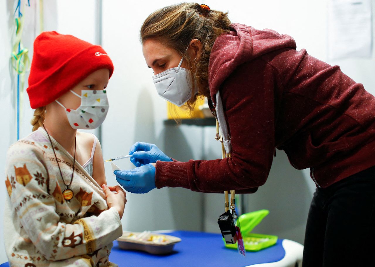FILE PHOTO: A nine-year-old girl receives a dose of the Pfizer-BioNTech vaccine for children against the coronavirus disease (COVID-19) during a vaccination event for children at the Lanxess Arena in Cologne, Germany, December 18, 2021. REUTERS/Thilo Schmuelgen