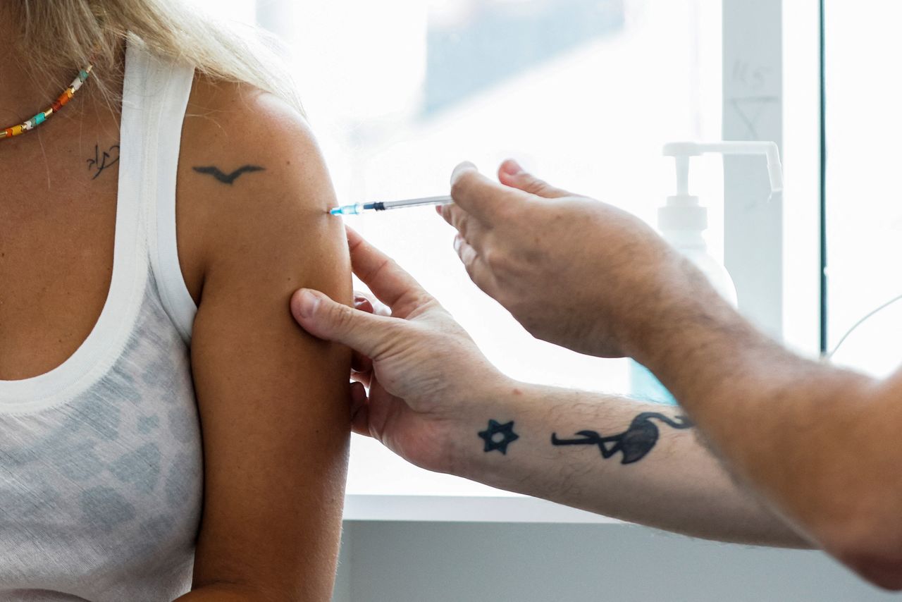 FILE PHOTO: An Israeli woman receives a third shot of coronavirus disease (COVID-19) vaccine in Tel Aviv, Israel August 30, 2021. REUTERS/Amir Cohen