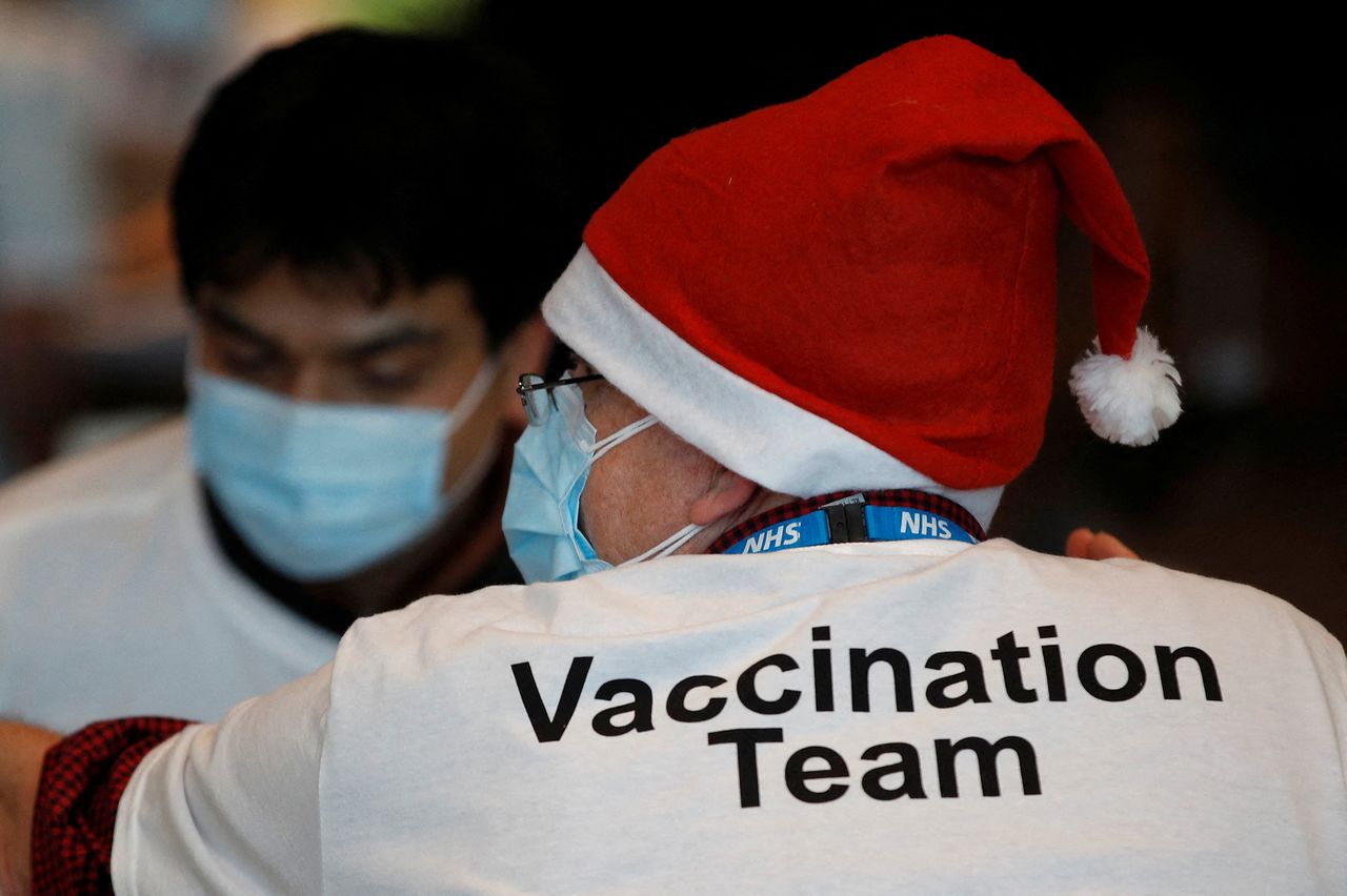 FILE PHOTO: A healthcare professional wears a Santa Claus hat at a coronavirus disease (COVID-19) pop-up vaccination centre at Wembley Stadium in London, Britain, December 19, 2021.  REUTERS/Peter Nicholls