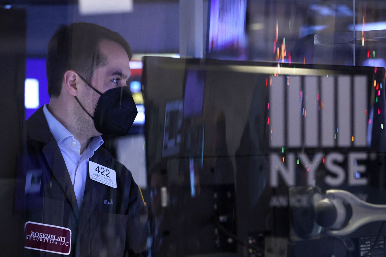 A trader in a face mask works on the trading floor at the New York Stock Exchange (NYSE) in Manhattan, New York City, U.S., December 17, 2021. REUTERS/Andrew Kelly